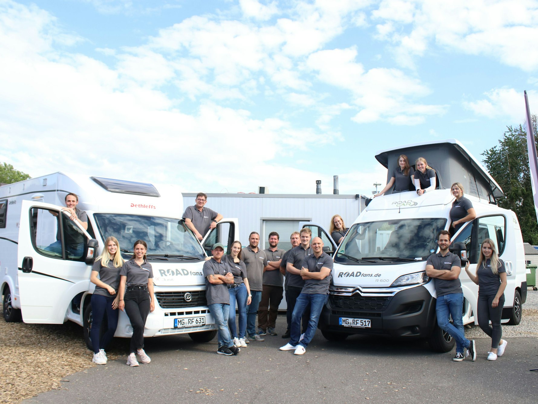 Das Team von roadfans steht vor zwei ihrer Fahrzeuge.