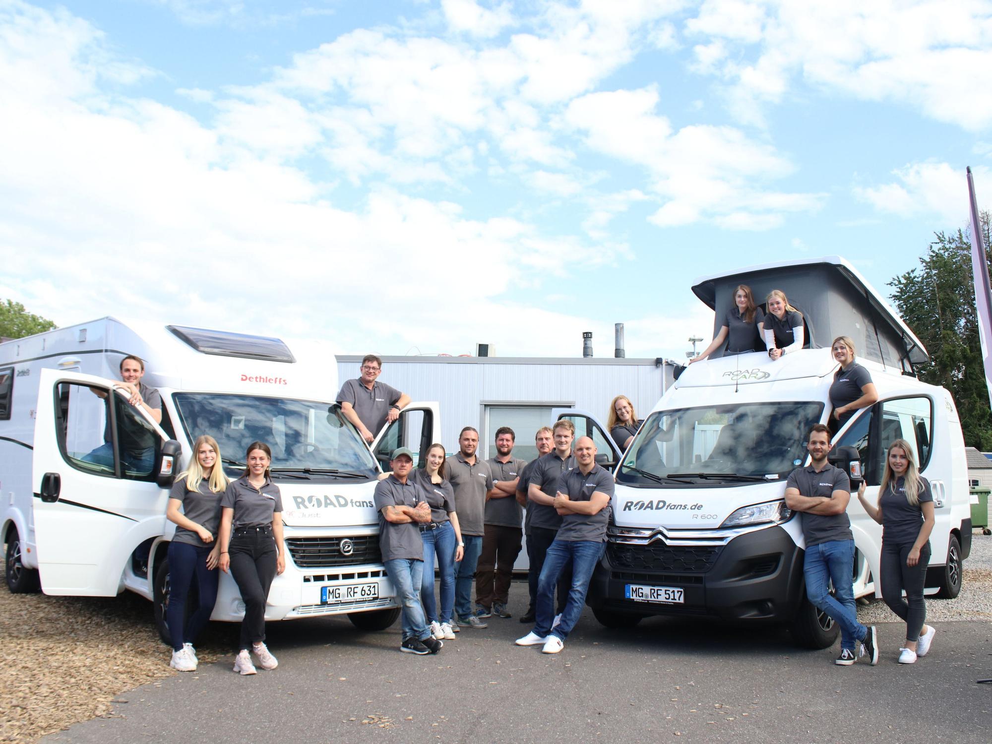 Das Team von roadfans steht vor zwei ihrer Fahrzeuge.