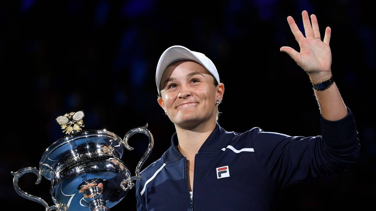 Ashleigh Barty hält den Pokal der Australian Open in der Hand und winkt.