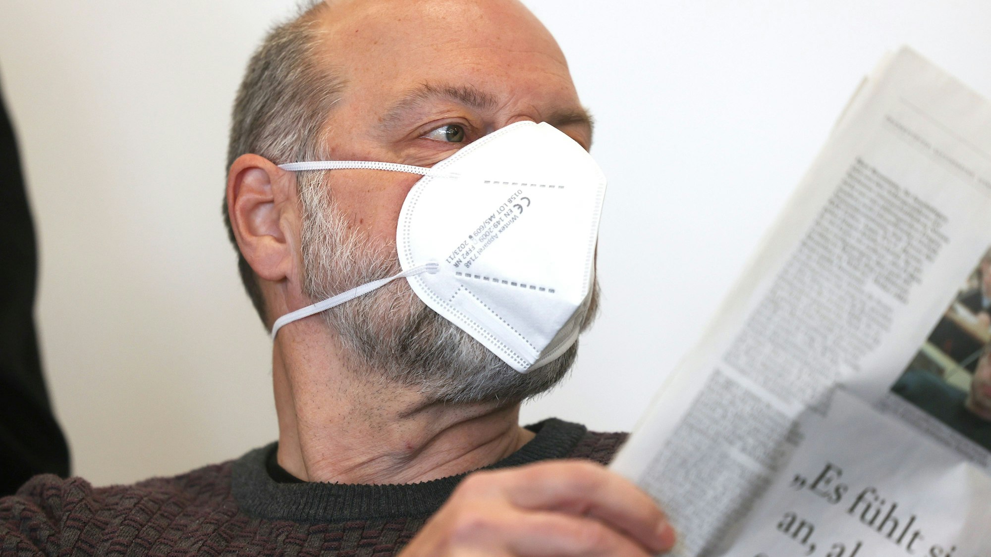 Der Angeklagte Thomas Drach blickt im Verhandlungsaal in eine Zeitung.