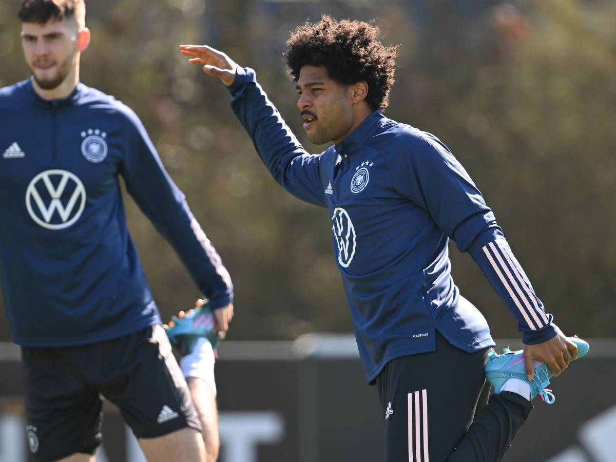 Serge Gnabry (rechts) dehnt sich im Training.