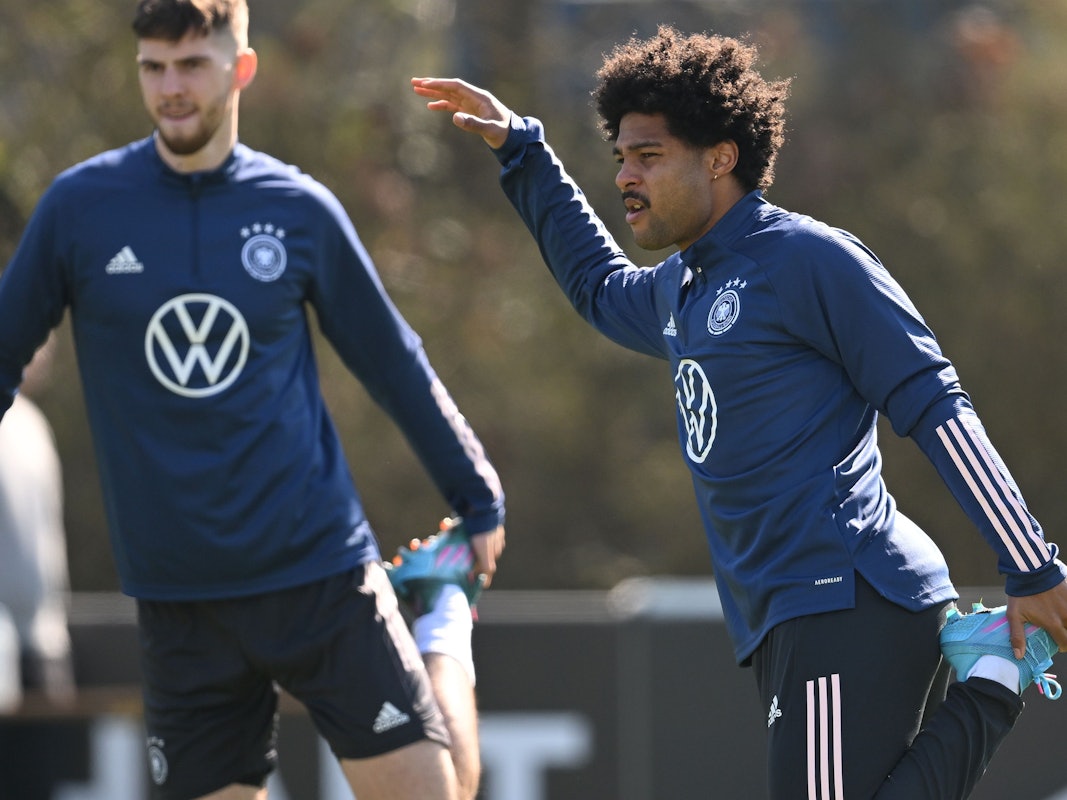 Serge Gnabry (rechts) dehnt sich im Training.