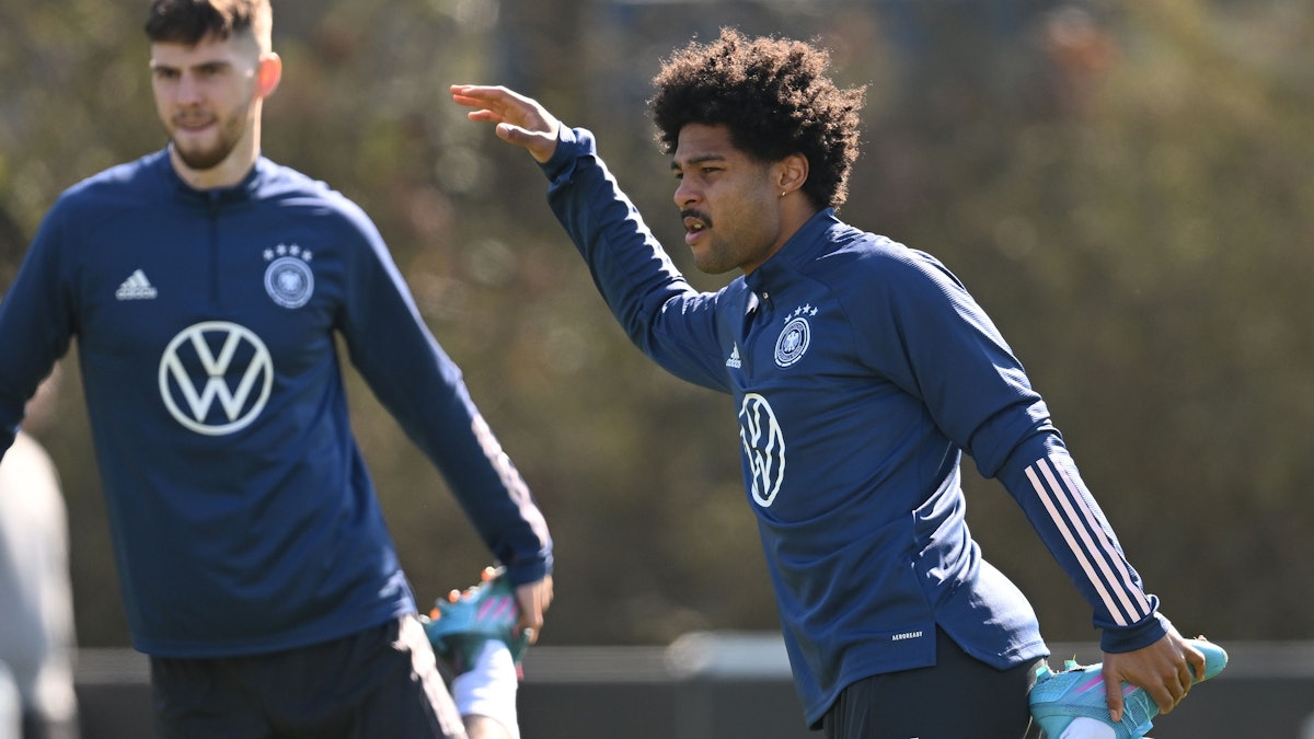 Serge Gnabry (rechts) dehnt sich im Training.
