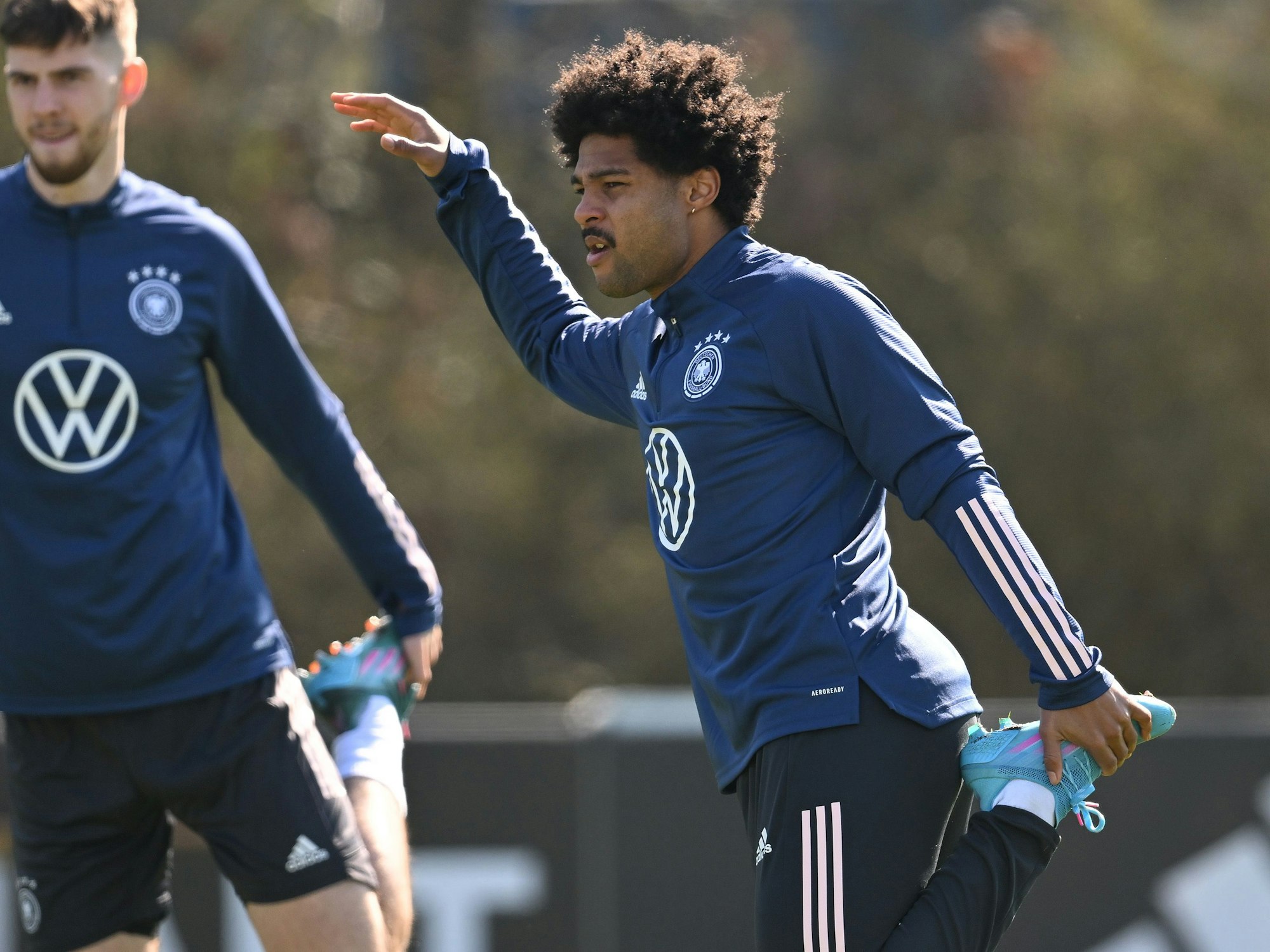 Serge Gnabry (rechts) dehnt sich im Training.