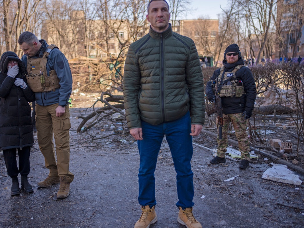 Vitali Klitschko (2.v.l), Bürgermeister von Kyjiw, tröstet eine weinende Nachbarin an dem Ort, an dem ein Bombenangriff Wohngebäude beschädigt hat, neben seinem Bruder Wladimir Klitschko (vorne).