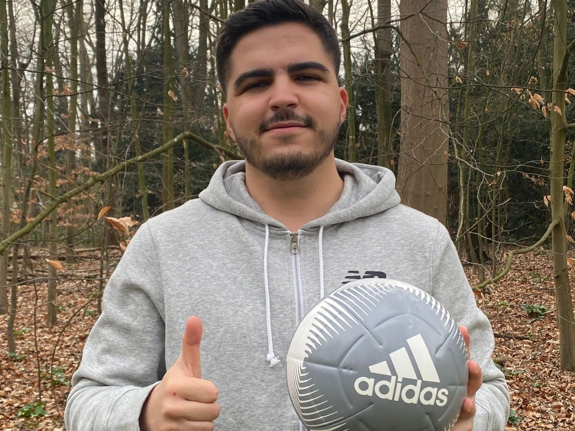 Der Krefelder Amateurfußballer Kürsat Karadag hält den Daumen in die Kamera und lächelt.