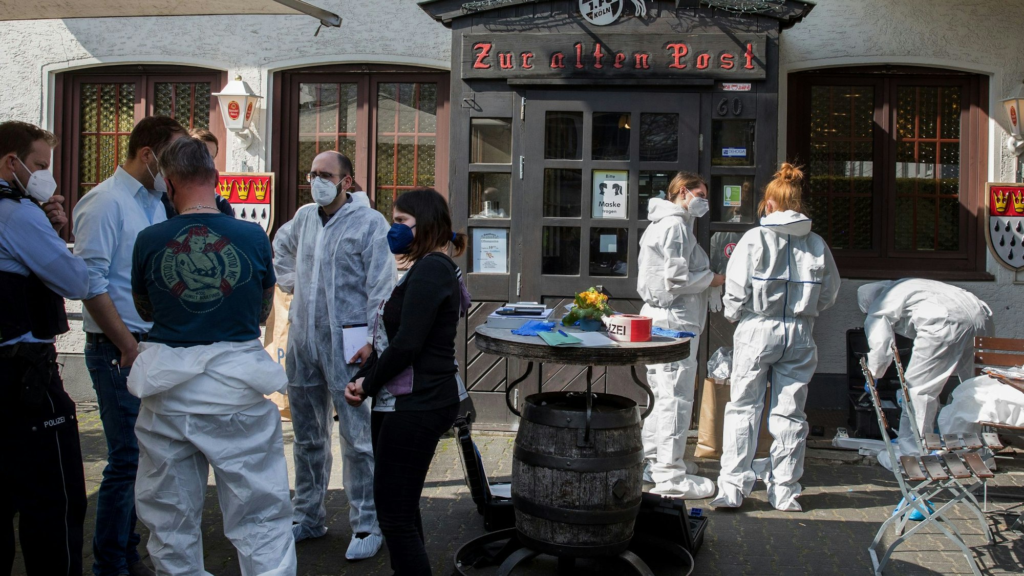 Männer und Frauen, zum Teil in Overalls, stehen vor der Gaststätte „Zur alten Post“.
