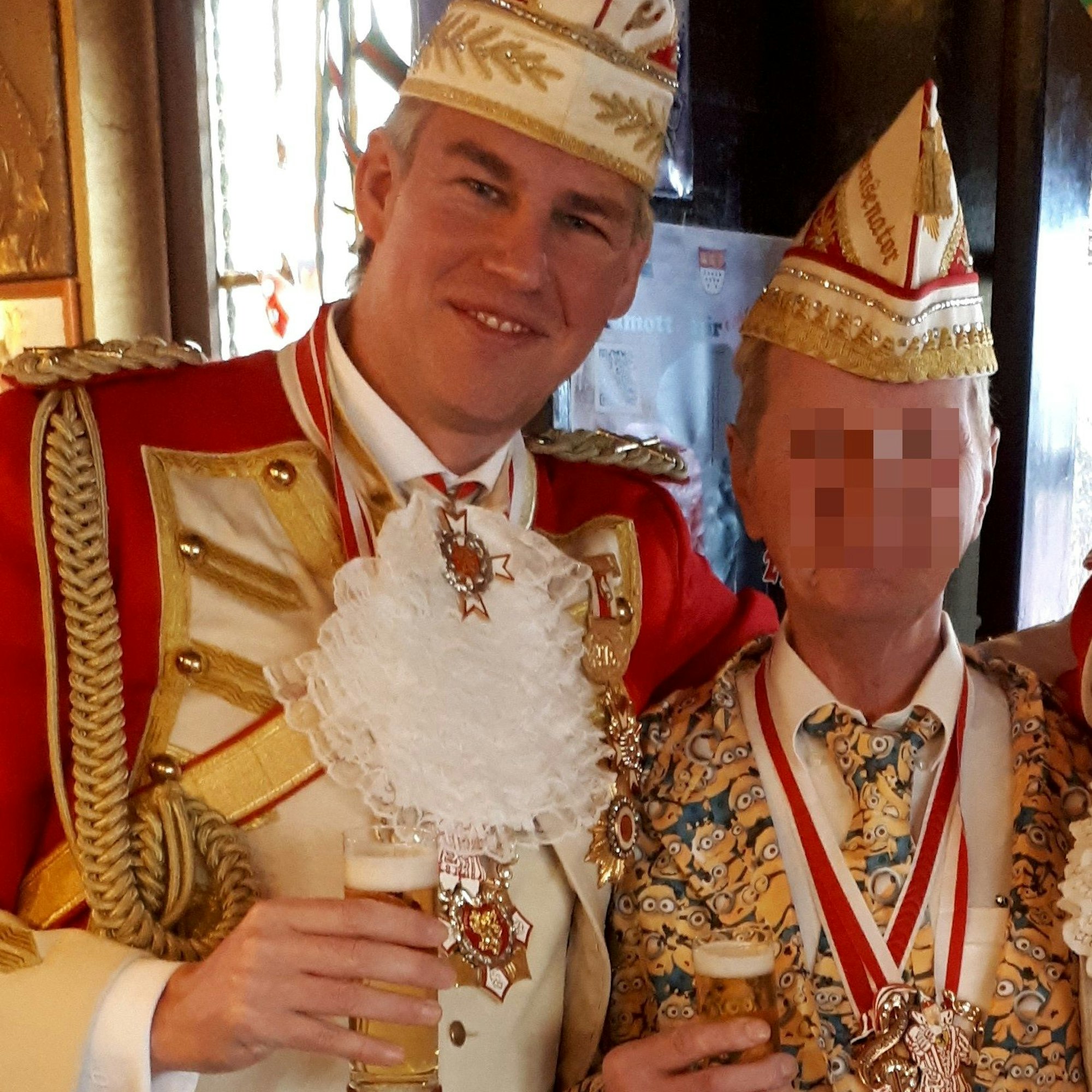 Manfred K. steht neben Stefan Hoeft, dem Präsidenten der Prinzengarde Frechen e. V. Beide sind kostümiert und halten ein Kölsch in der Hand.