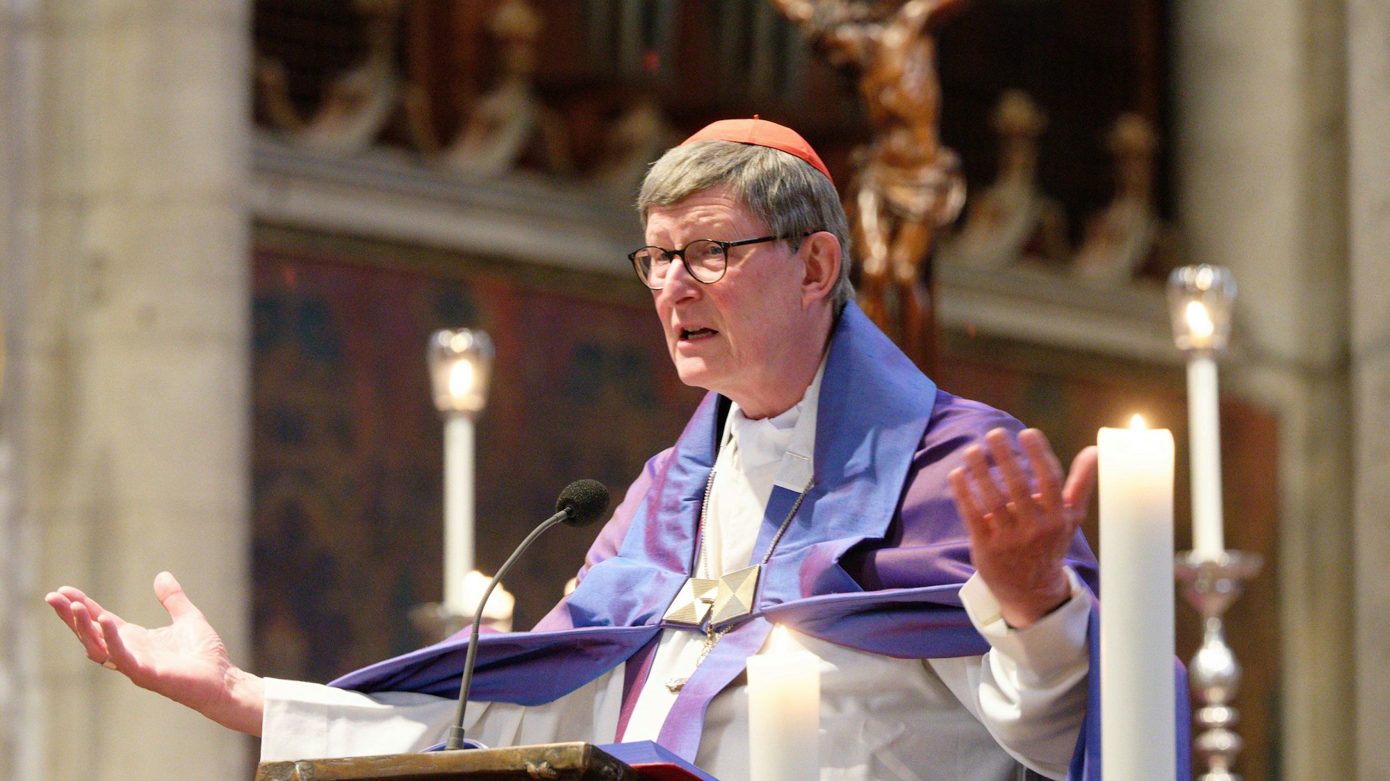 Kardinal Woelki predigt mit ausgebreiteten Armen.