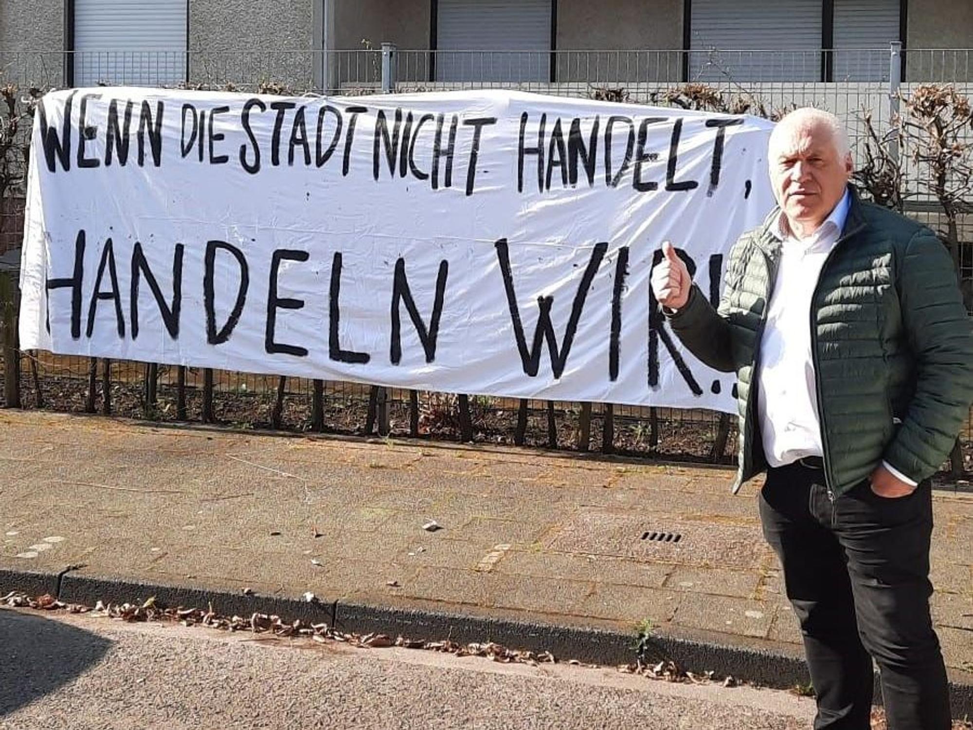 Kalle Gerigk steht vor dem besetzten Haus in Köln und hält den Daumen hoch.