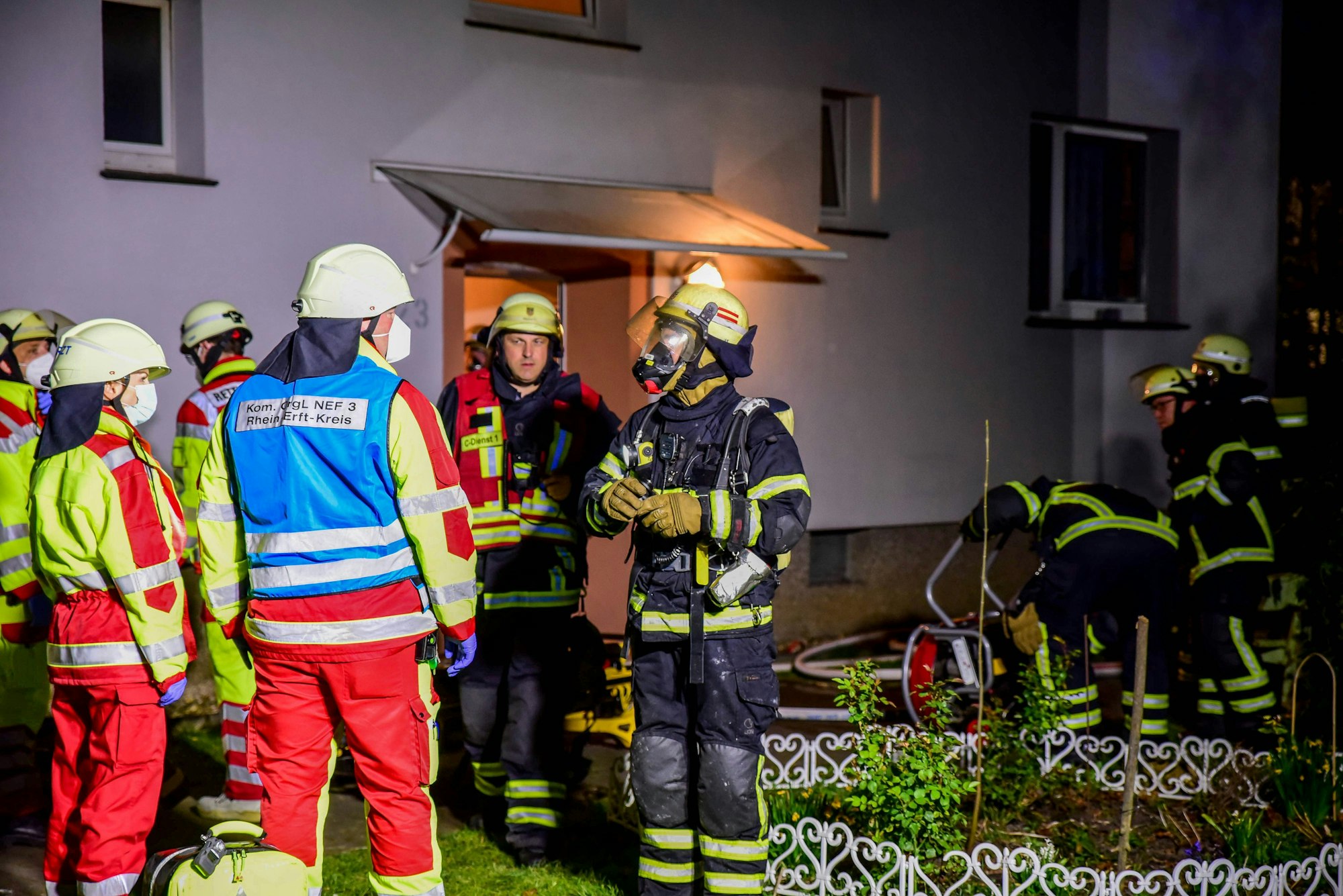 Feuerwehrleute arbeiten vor einem Haus in dem eine Wohnung gebrannt hat.