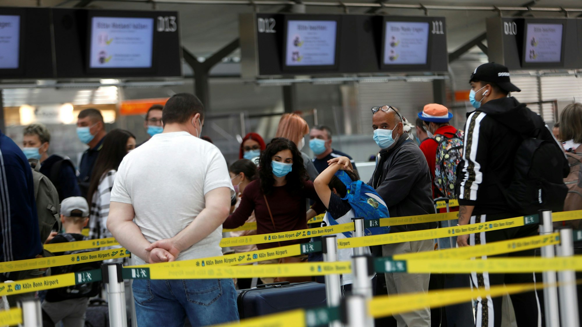 Menschen warten am Check-in am Flughafen Köln/Bonn.