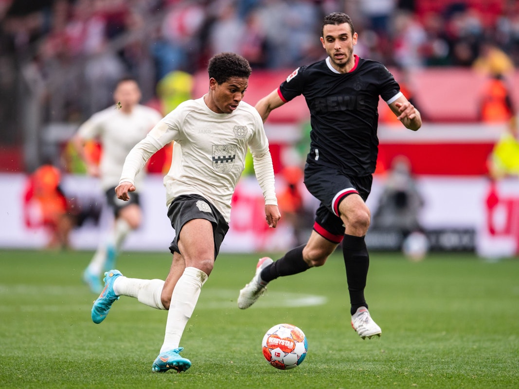 Leverkusens Amine Adli (l) spielt im Laufduell mit Ellyes Skhiri den Ball.