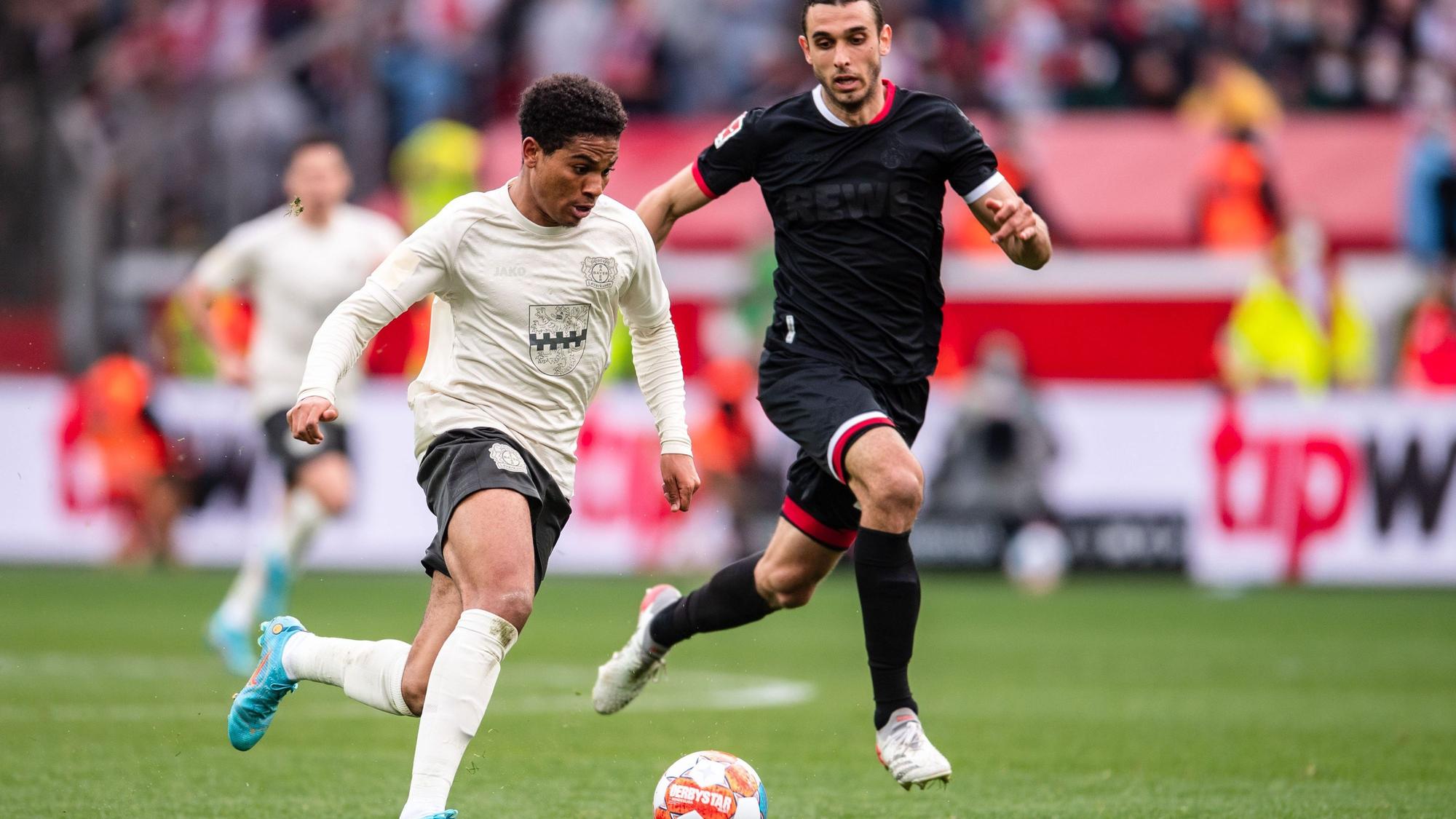 Leverkusens Amine Adli (l) spielt im Laufduell mit Ellyes Skhiri den Ball.