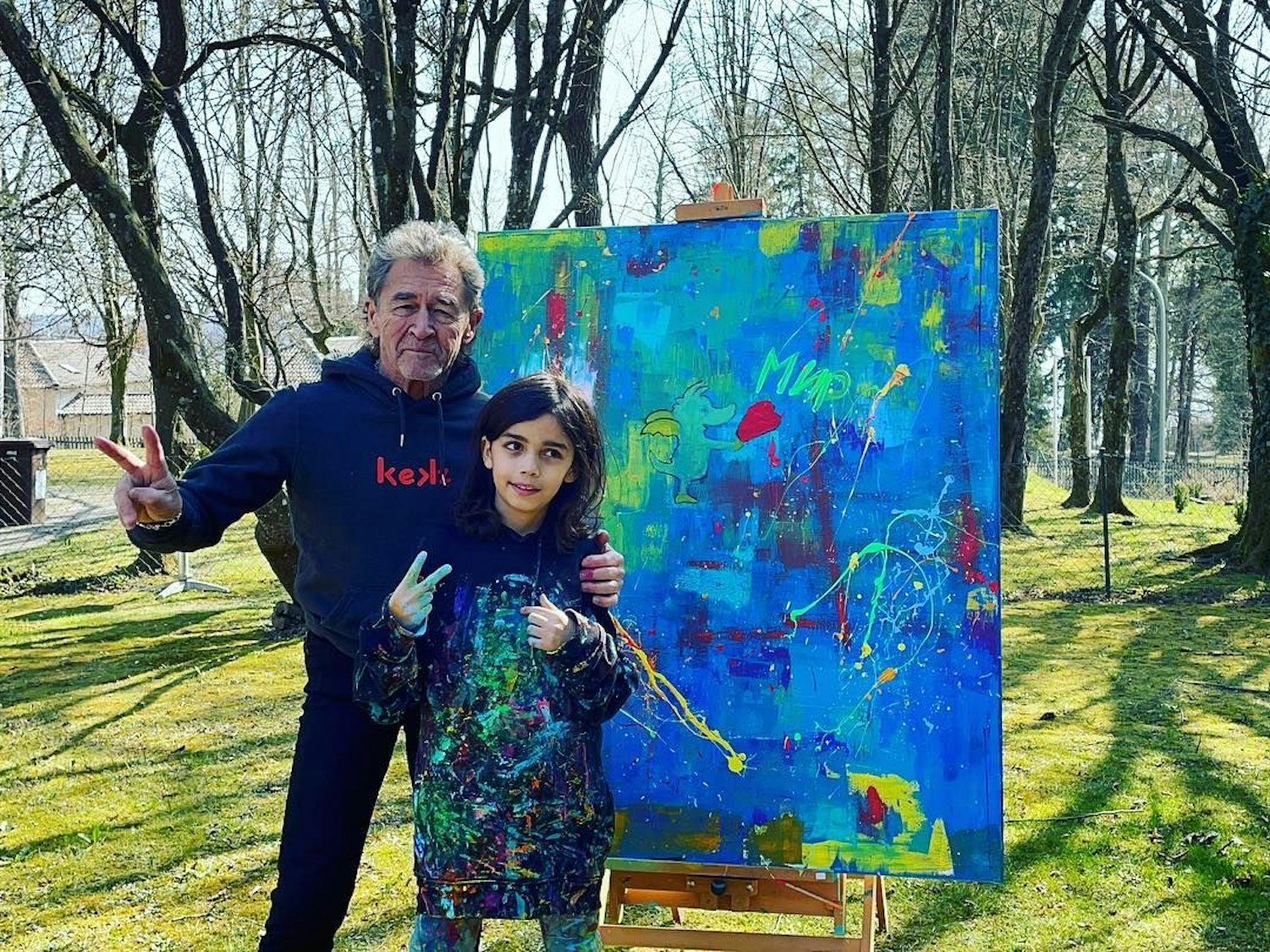 Maler Mikail Akar und Peter Maffay stehen vor einem Gemälde.