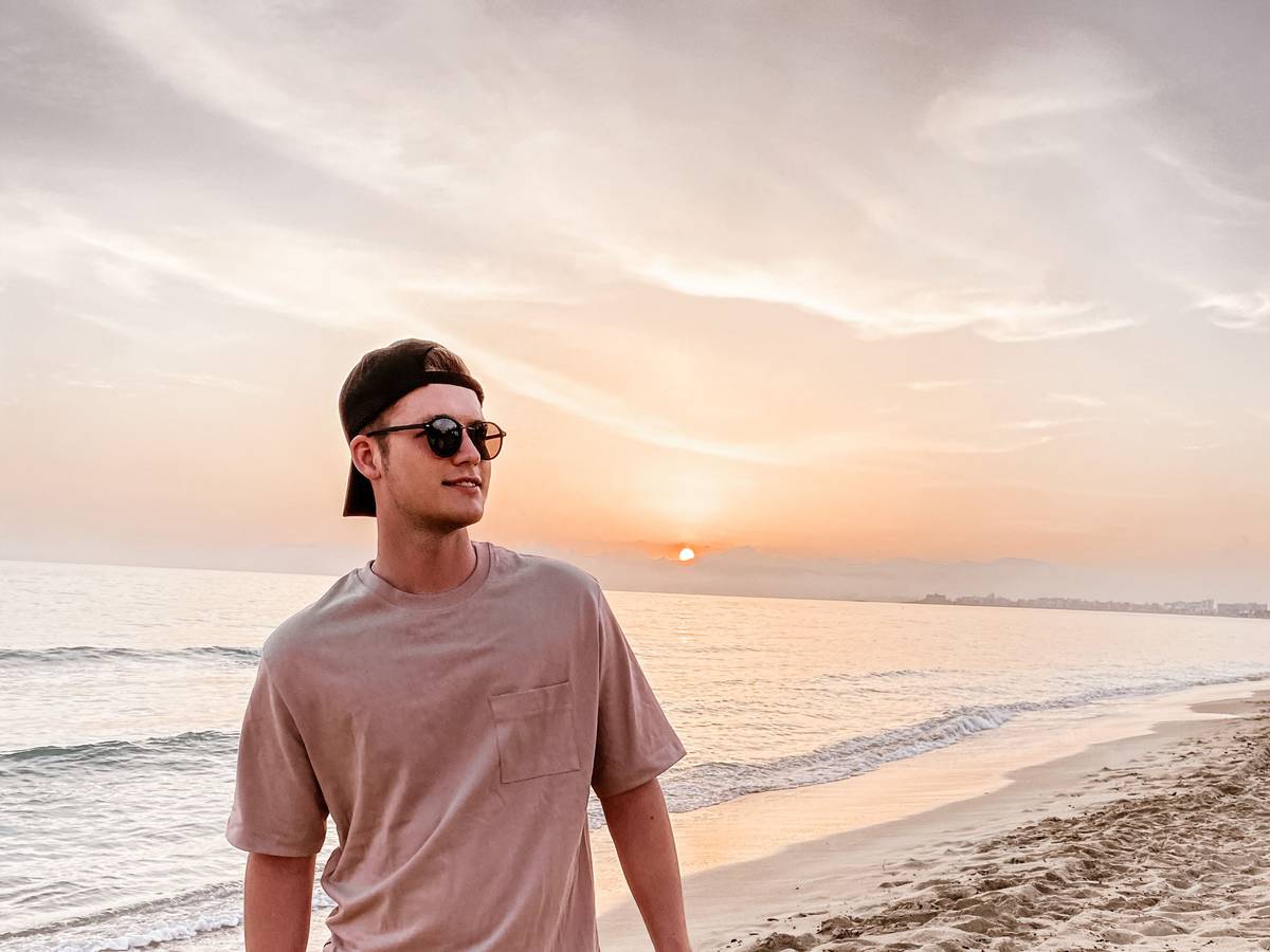 Sänger Julian Sommer steht am Strand auf Mallorca.