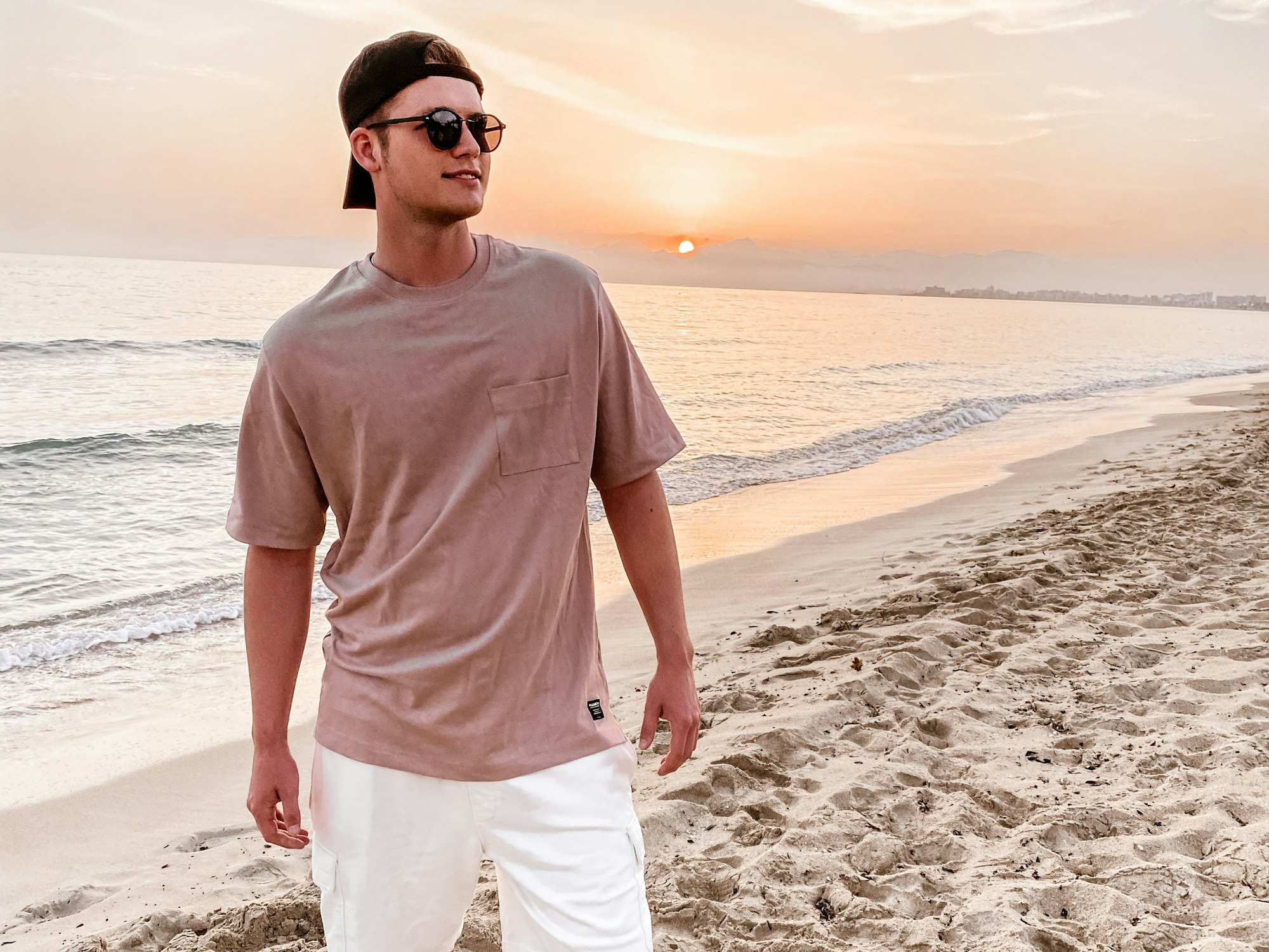 Sänger Julian Sommer steht am Strand auf Mallorca.