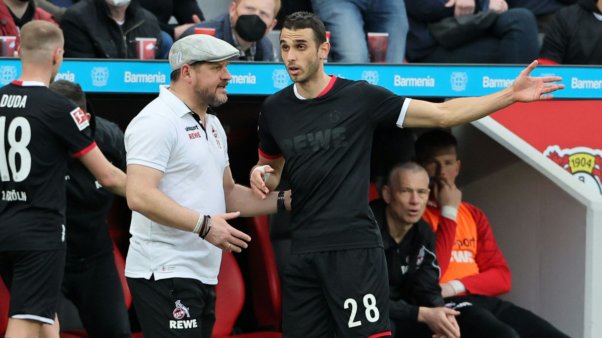 Steffen Baumgart spricht beim Bundesliga-Spiel Bayer Leverkusen gegen 1. FC Köln mit Ellyes Skhiri.