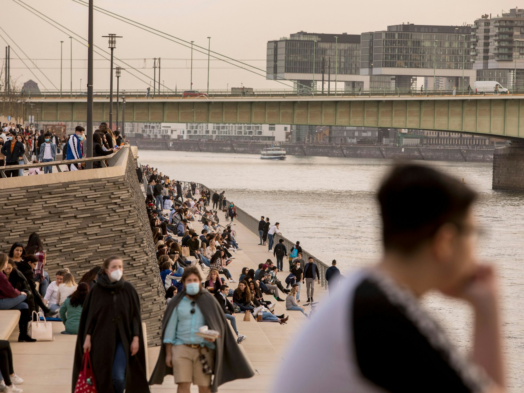 Abendstimmung an der Treppe am Rheinboulevard in Deutz (Foto vom 25. Februar 2021). Der Sonnenuntergang über Köln erscheint aufgrund großer Mengen Saharastaub besonders milchig und trüb.