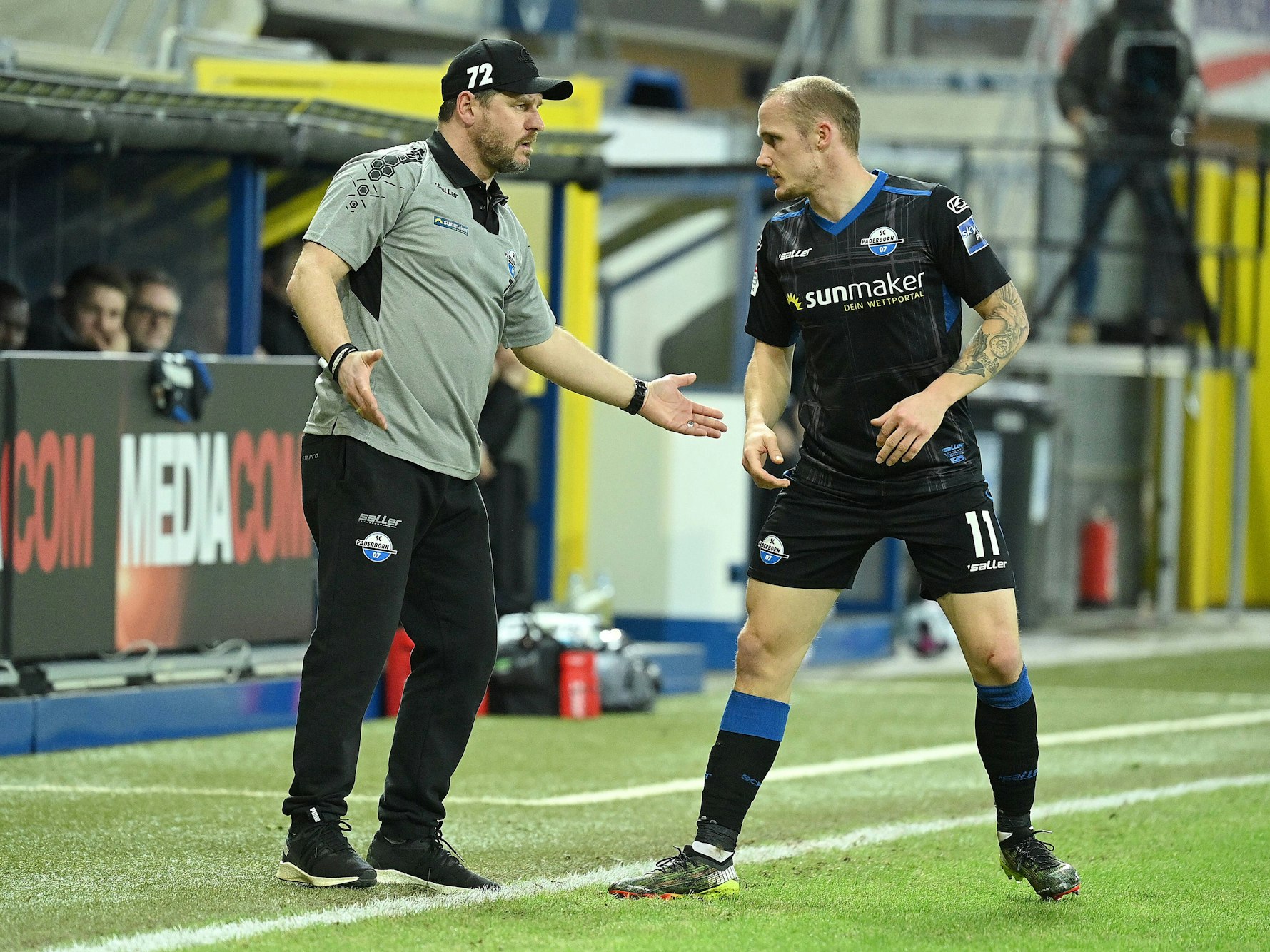 Steffen Baumgart spricht an der Seitenlinie mit seinem Spieler Sven Michel.