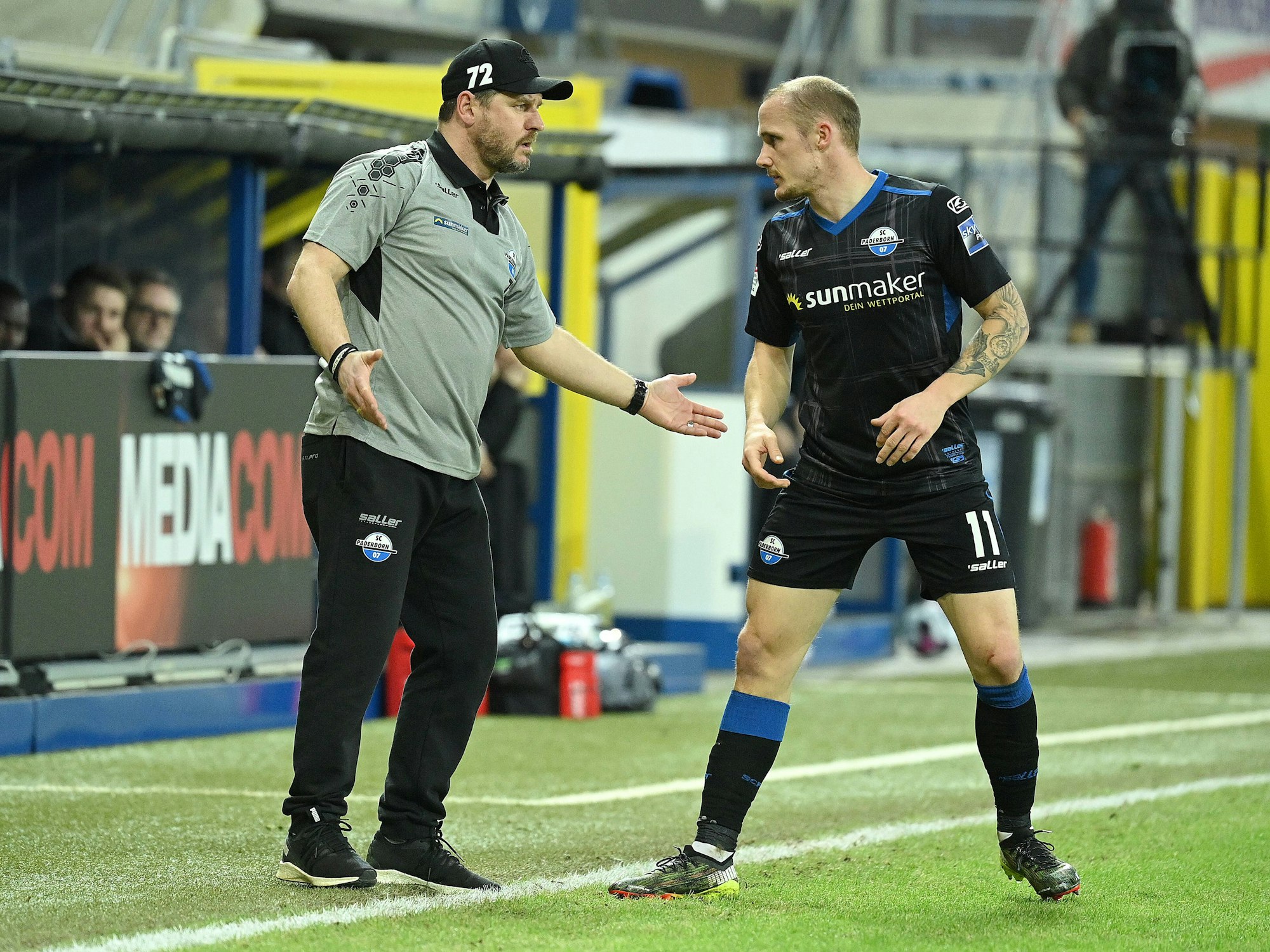 Steffen Baumgart spricht an der Seitenlinie mit seinem Spieler Sven Michel.