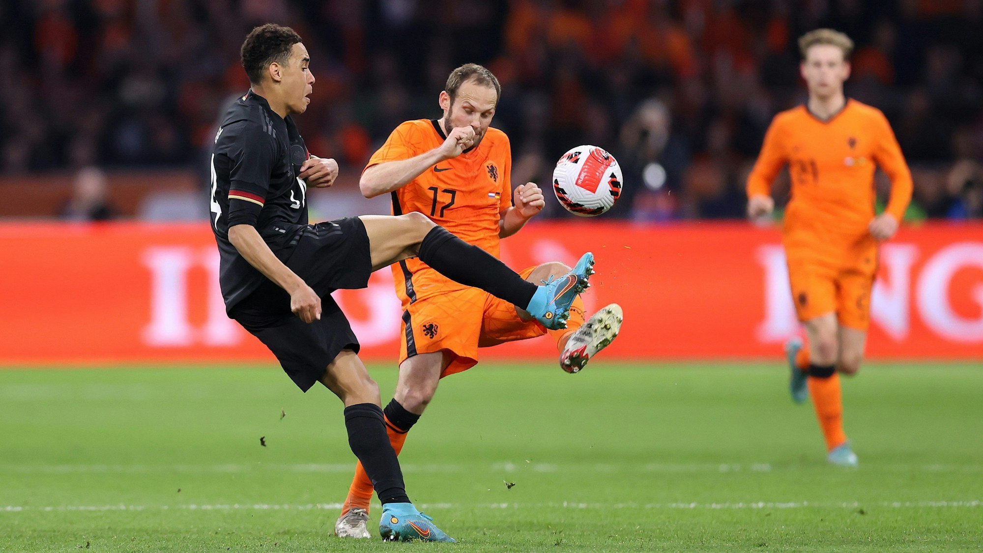 Jamal Musiala hebt den Ball über Daley Blind.