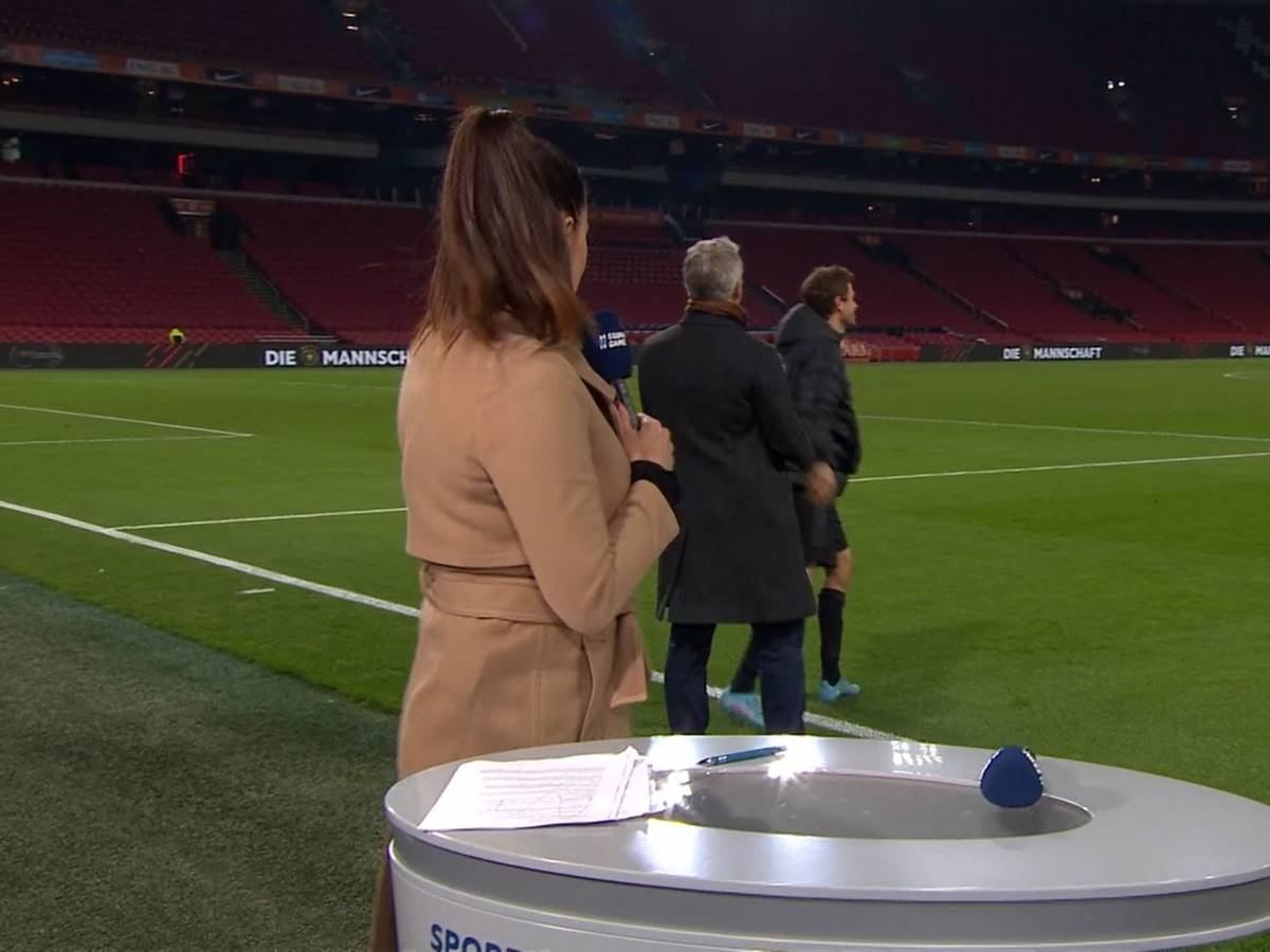 Esther Sedlaczek dreht sich zu Bastian Schweinsteiger um, der nach dem DFB-Spiel in den Niederlanden mit Thomas Müller spricht.