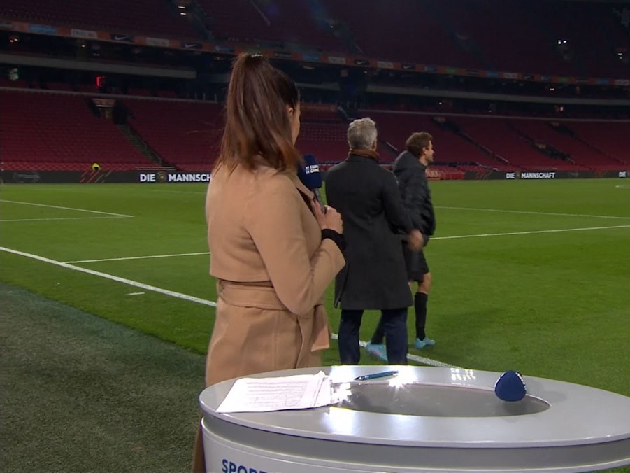 Esther Sedlaczek dreht sich zu Bastian Schweinsteiger um, der nach dem DFB-Spiel in den Niederlanden mit Thomas Müller spricht.