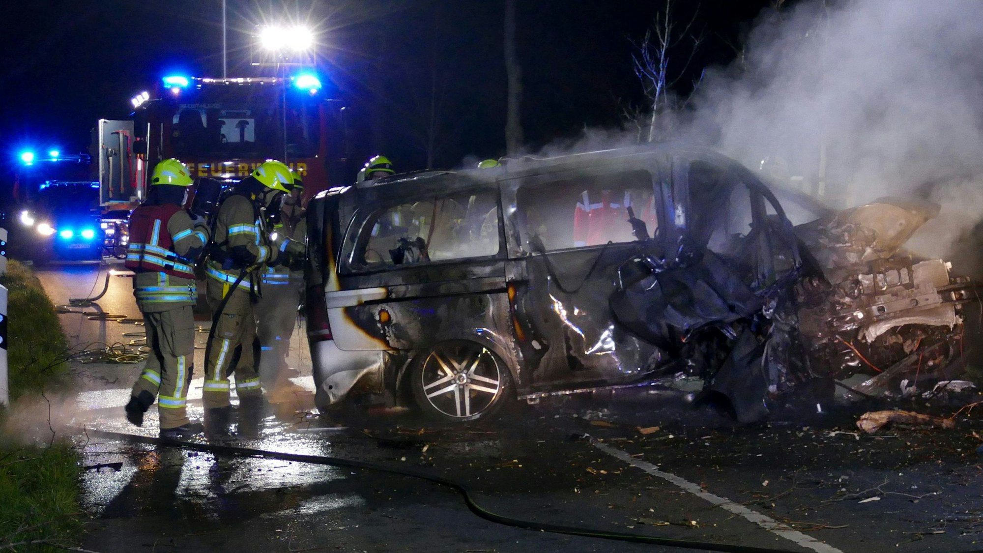 Die Feuerwehr steht vor dem Wrack eines ausgebrannten Autos, in dem zwei Menschen ums Leben gekommen sind.