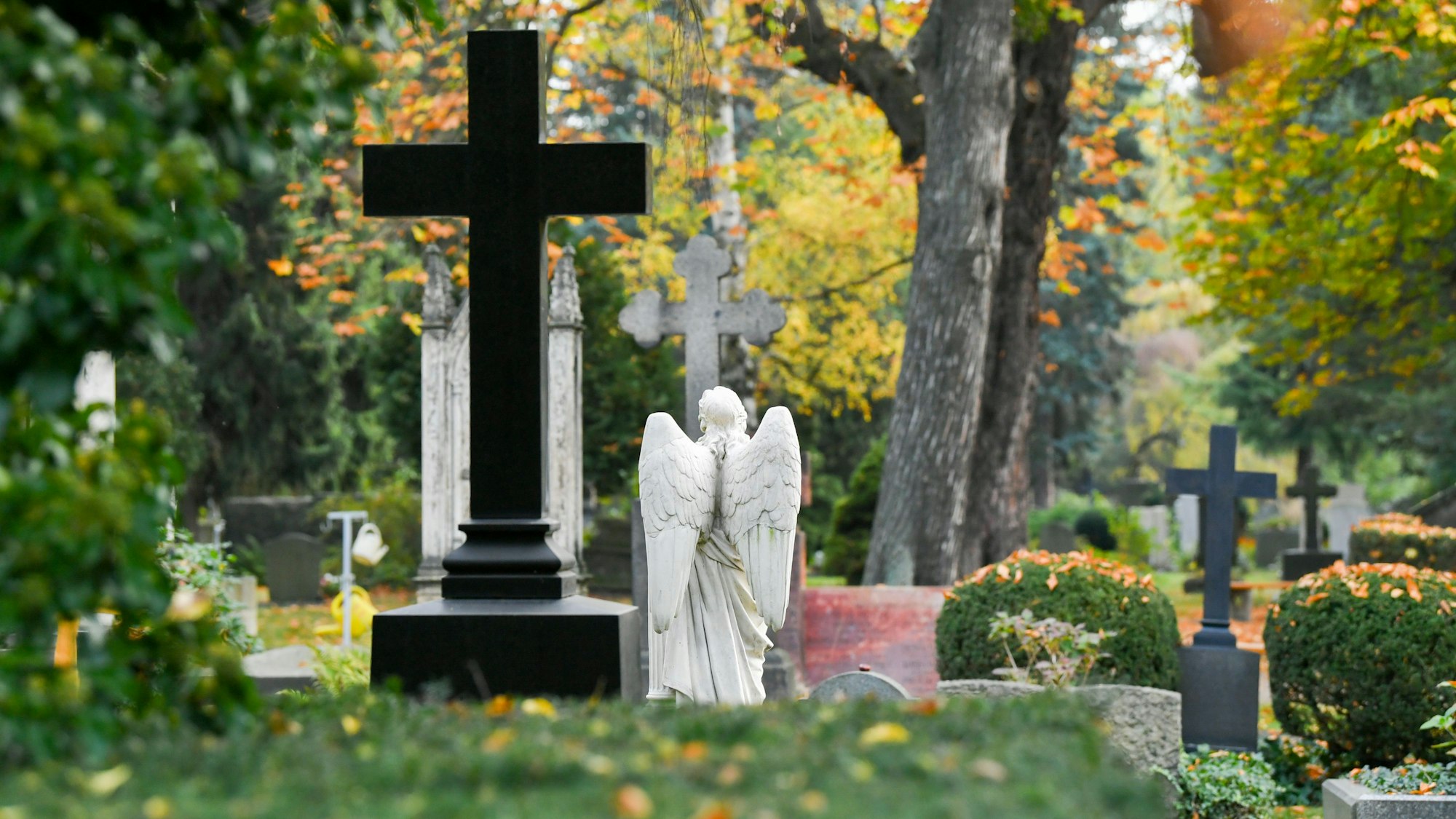 Kreuze und Figuren auf einem Friedhof.