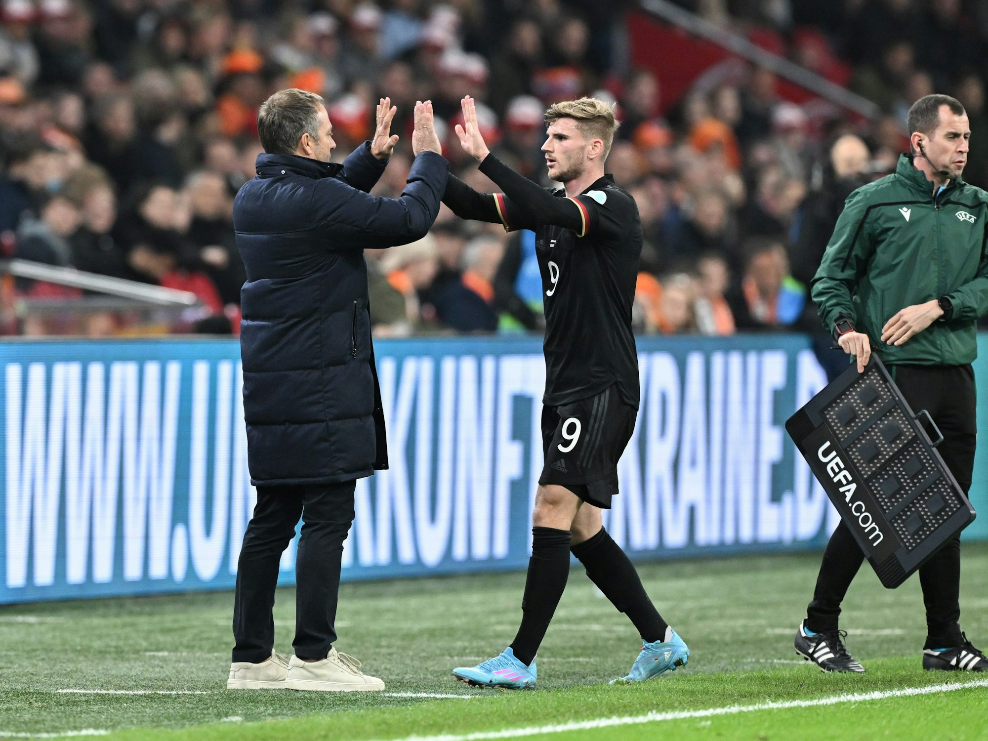 Deutschlands Trainer Hansi Flick (l) klatscht mit Deutschlands Timo Werner bei seiner Auswechslung ab.