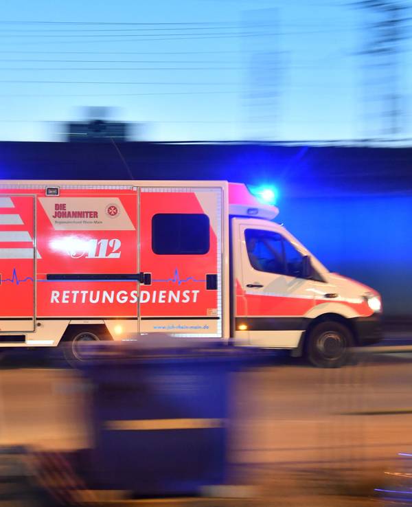 Ein Rettungswagen ist mit eingeschaltetem Blauchlicht im Einsatz.