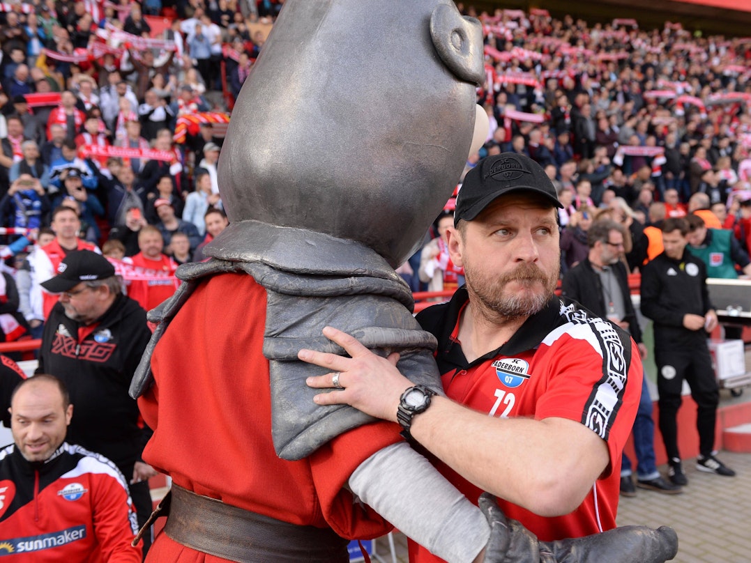 Steffen Baumgart umarmt das Maskottchen von Union Berlin.