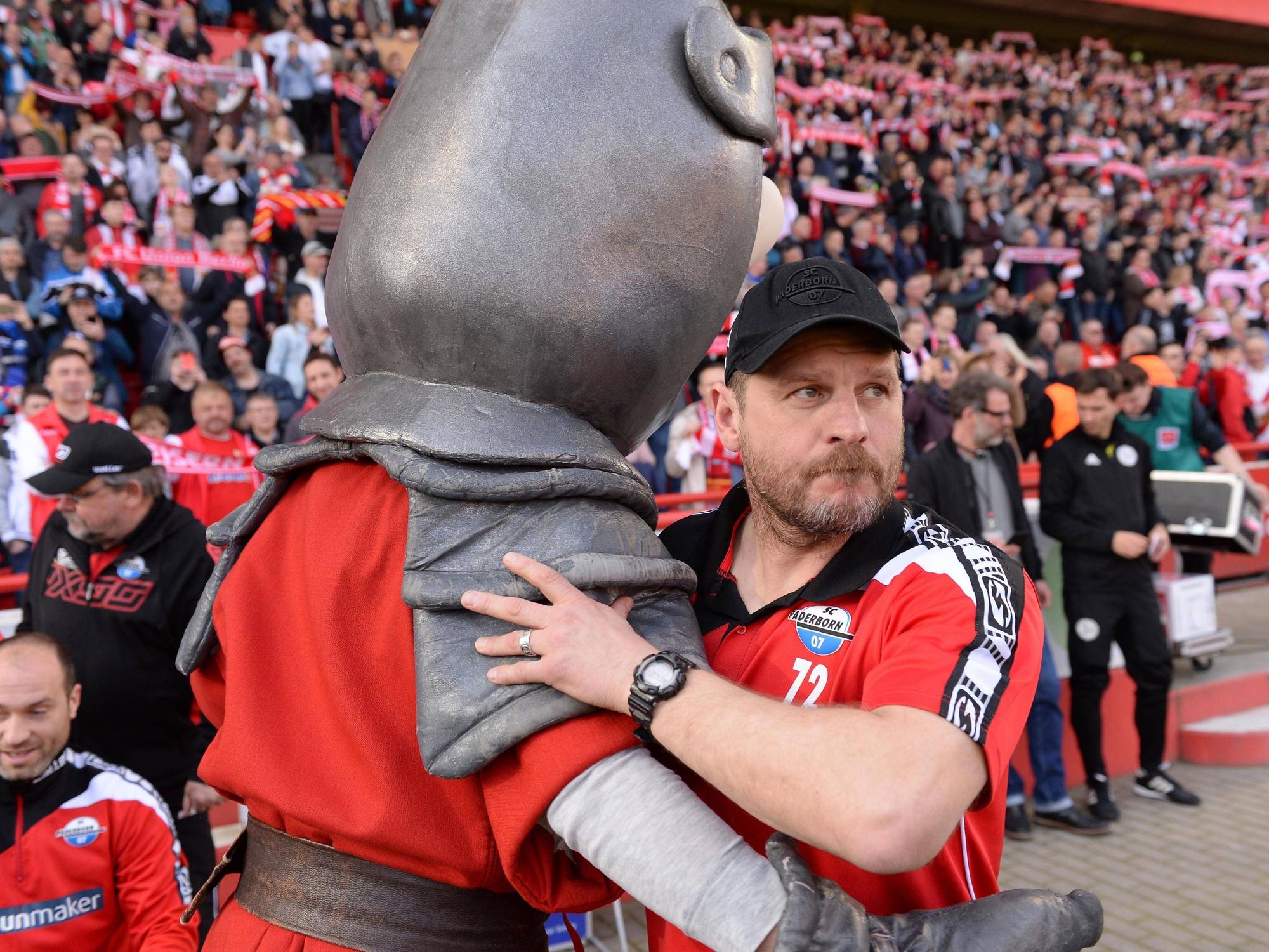 Steffen Baumgart umarmt das Maskottchen von Union Berlin.
