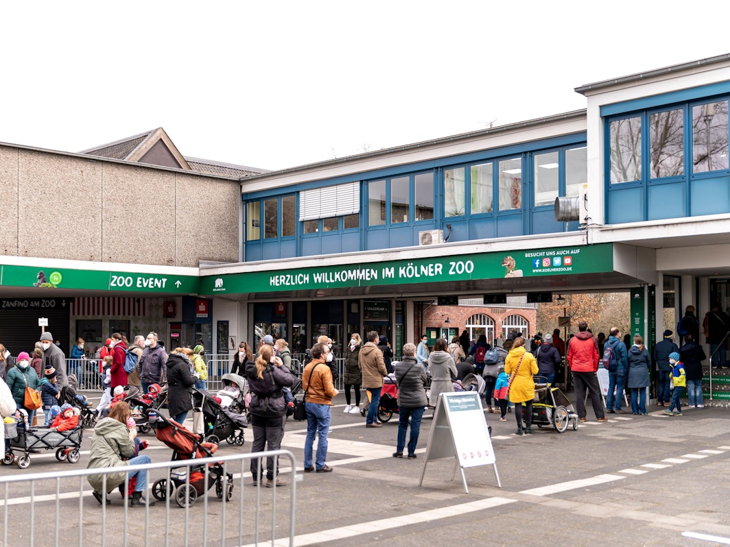 Menschen stehen vor dem Eingang des Kölner Zoos.