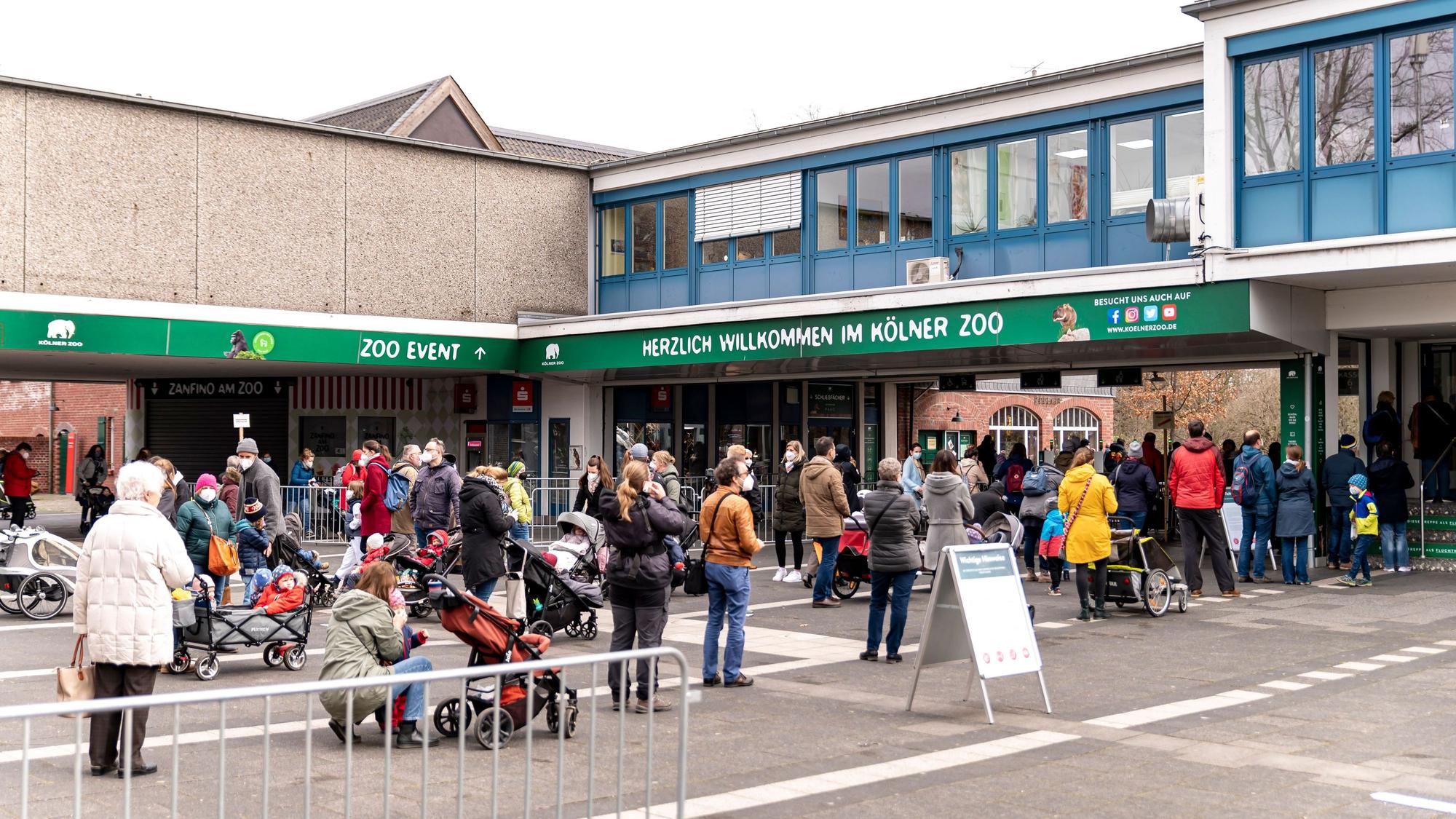 Menschen stehen vor dem Eingang des Kölner Zoos.