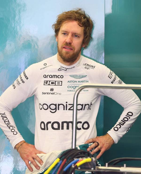 Sebastian Vettel spricht mit einem Teammitglied in der Garage des Aston Martin Teams.