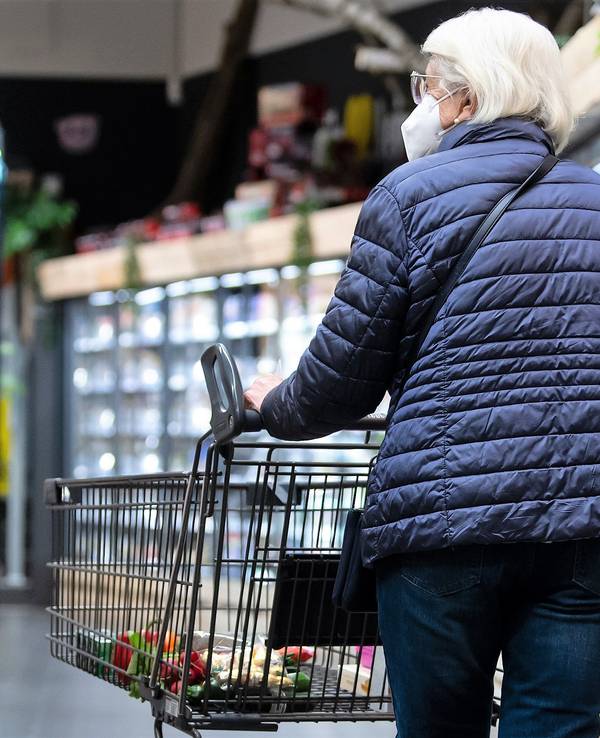Eine Frau geht Ende März mit ihrem Einkaufswagen durch einen Supermarkt – noch mit einer Maske. Ab April entfällt die Maskenpflicht auch in Supermärkten und Discountern.