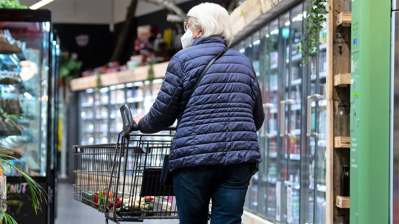 Eine Frau geht Ende März mit ihrem Einkaufswagen durch einen Supermarkt – noch mit einer Maske. Ab April entfällt die Maskenpflicht auch in Supermärkten und Discountern.