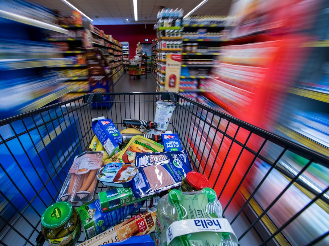 Ein Einkaufswagen mit Lebensmitteln wird am 30. November 2017 in Schwerin (Mecklenburg-Vorpommern) durch die Regalreihen in einem Supermarkt geschoben.