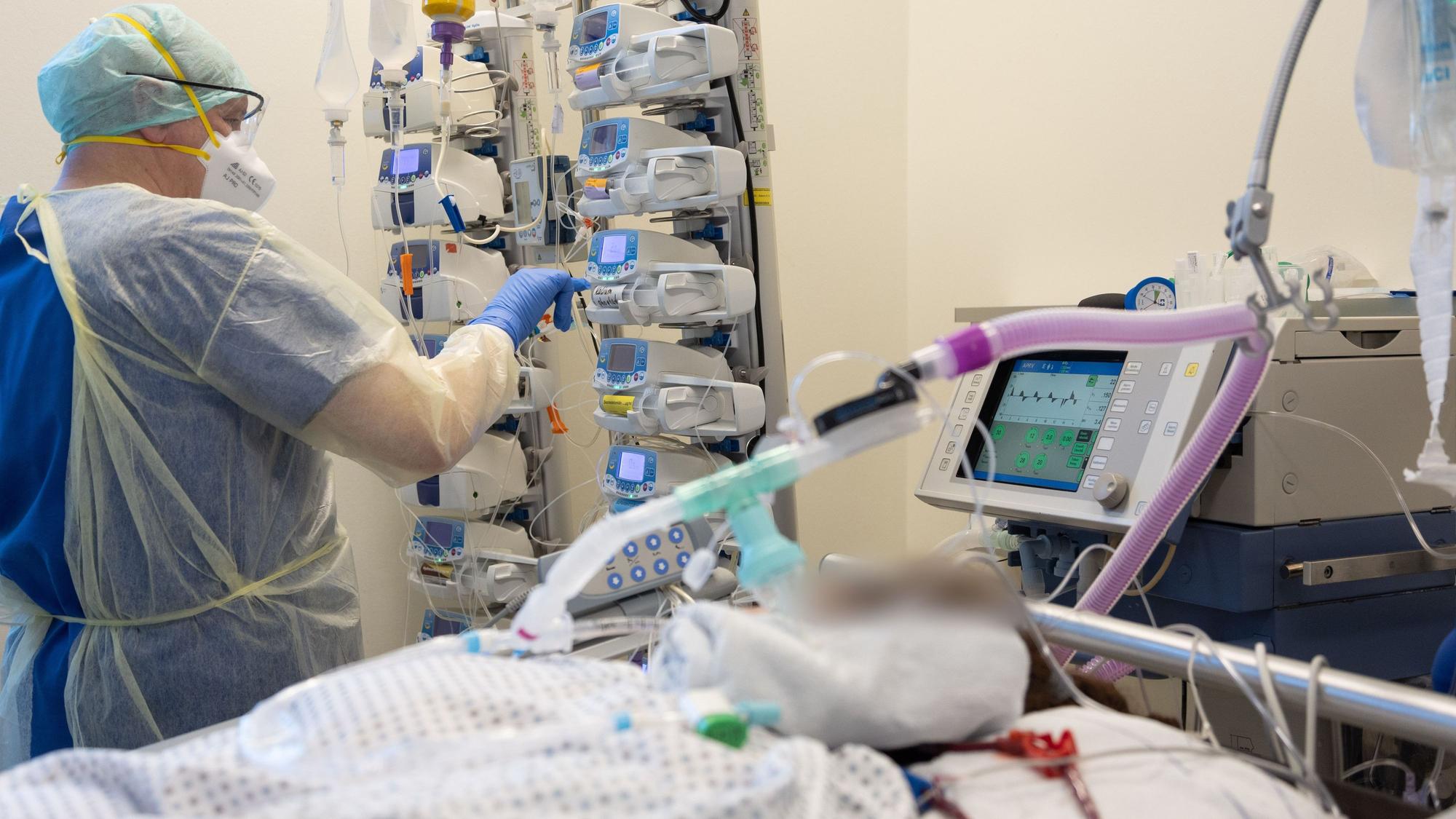 Die Lage in vielen deutschen Kliniken verschärft sich wegen des Krankenstands zusehends. Ein Krankenpfleger versorgt Ende März einen schwer an Corona erkrankten Patienten auf der Intensivstation von einem Krankenhaus in Niedersachsen.