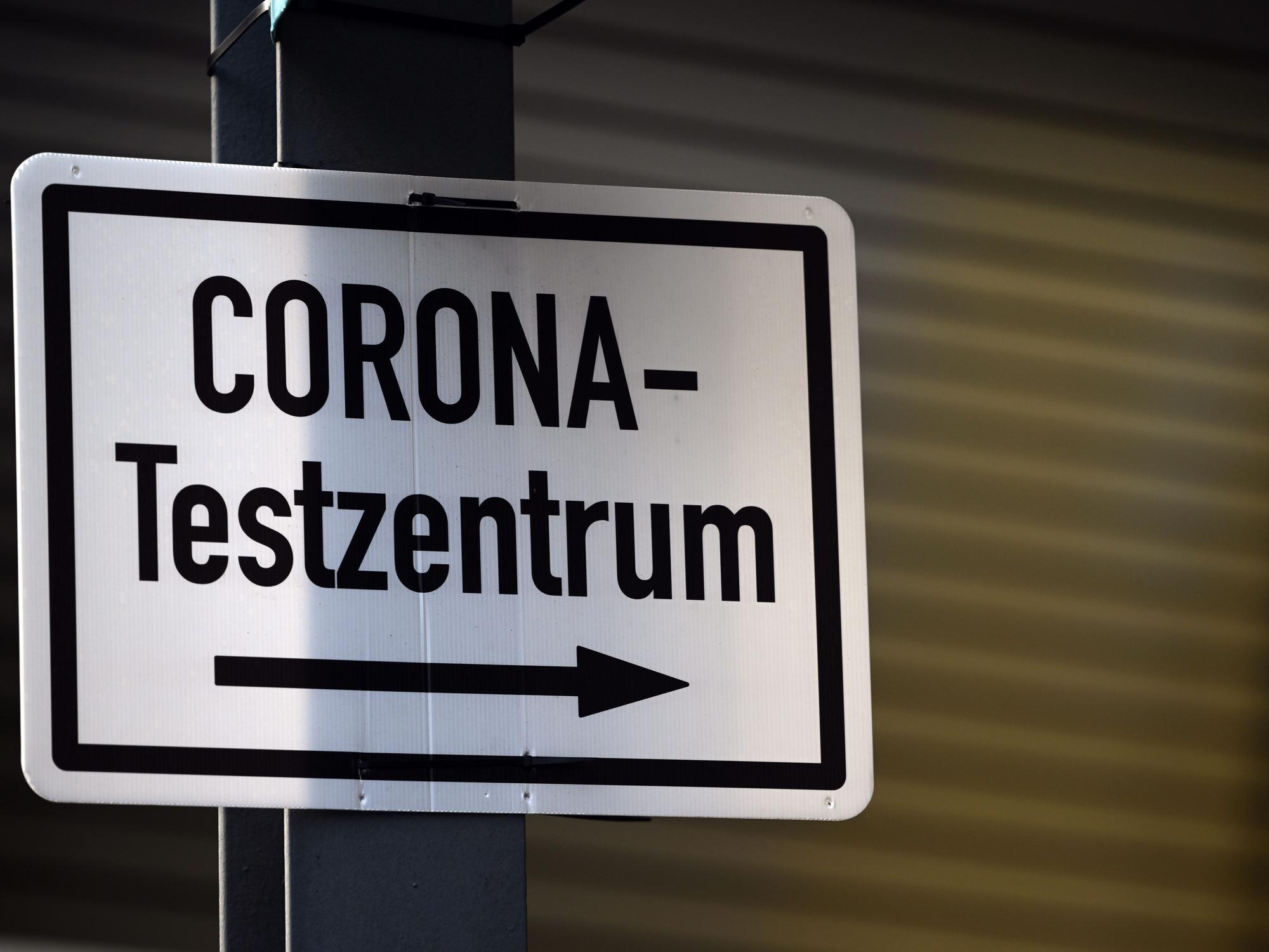 Ein Schild weist den Weg zu einen Corona-Testzentrum.