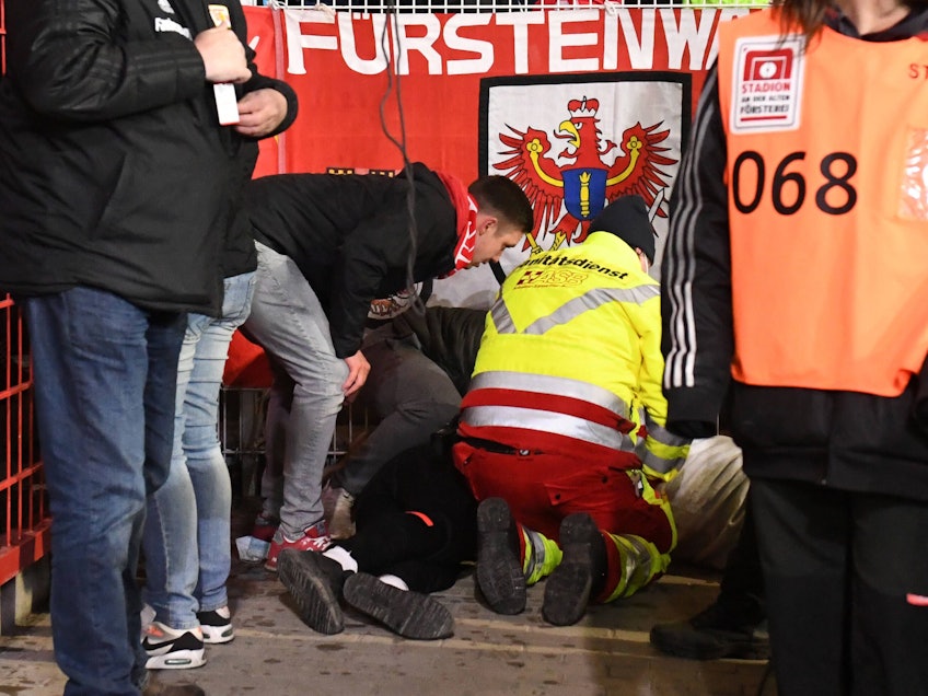 Ein verunglückter Fan wird beim Bundesliga-Spiel Union Berlin gegen den 1. FC Köln von Sanitätern versorgt