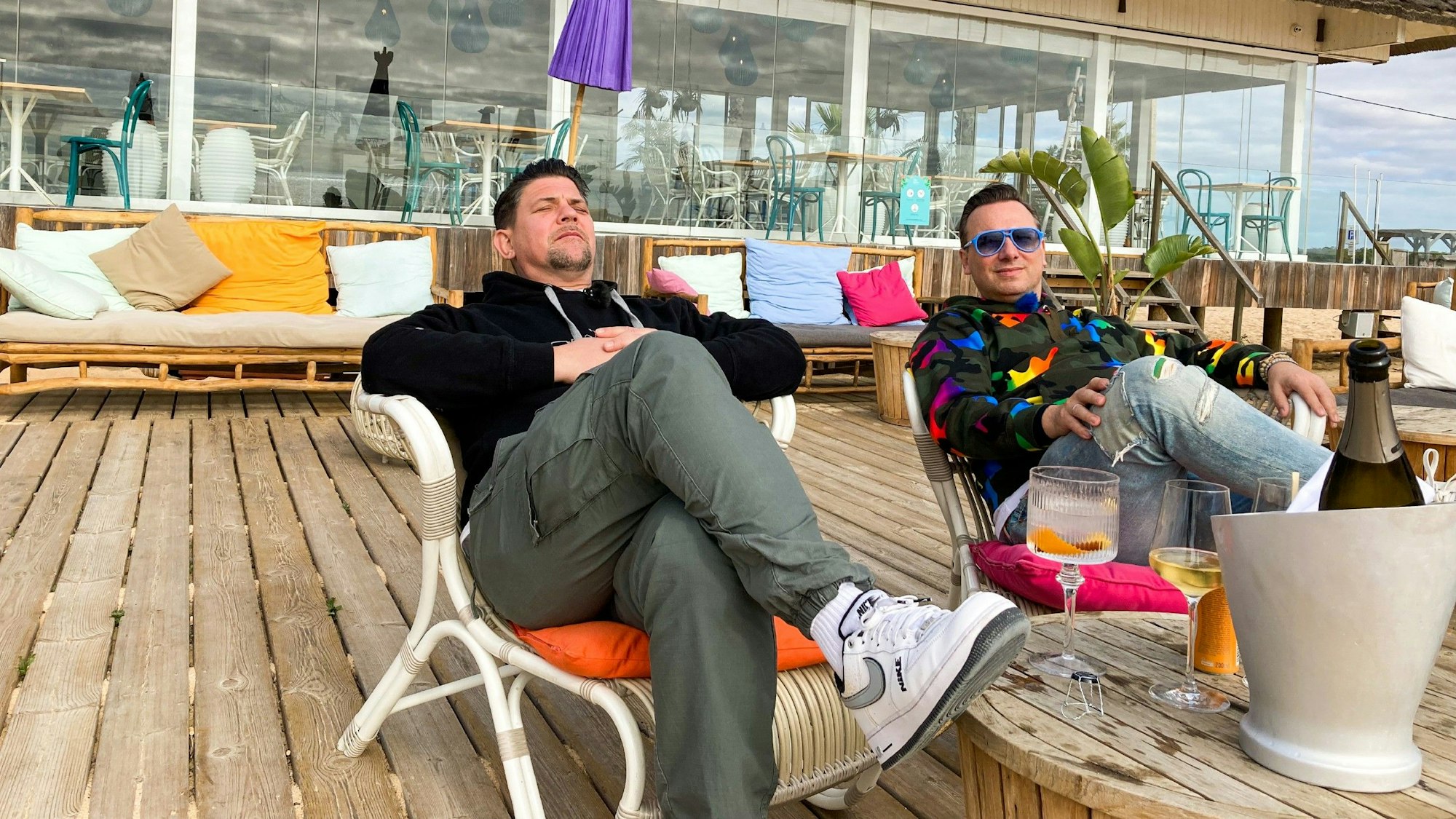 Tim Mälzer (l.) und Tim Raue liegen in Liegestühlen.