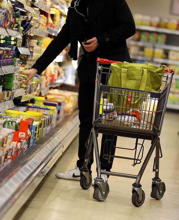 ARCHIV - Ein Kunde steht am 13.02.2012 in Köln in einem Supermarkt am Kühlregal. Die Deutschen greifen im Supermarkt immer häufiger zu Eigenmarken von Edeka, Rewe, Aldi und Co. statt zu den klassischen Markenartikeln. Foto: Oliver Berg/dpa (zu dpa vom 23.01.2015) +++ dpa-Bildfunk +++