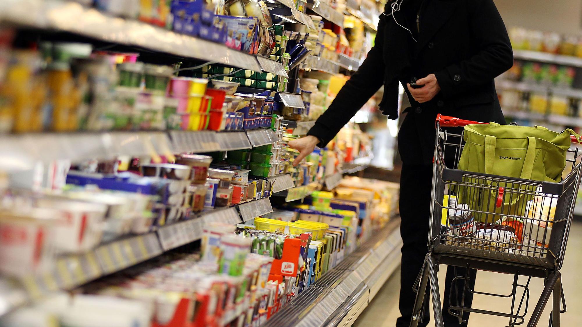 ARCHIV - Ein Kunde steht am 13.02.2012 in Köln in einem Supermarkt am Kühlregal. Die Deutschen greifen im Supermarkt immer häufiger zu Eigenmarken von Edeka, Rewe, Aldi und Co. statt zu den klassischen Markenartikeln. Foto: Oliver Berg/dpa (zu dpa vom 23.01.2015) +++ dpa-Bildfunk +++