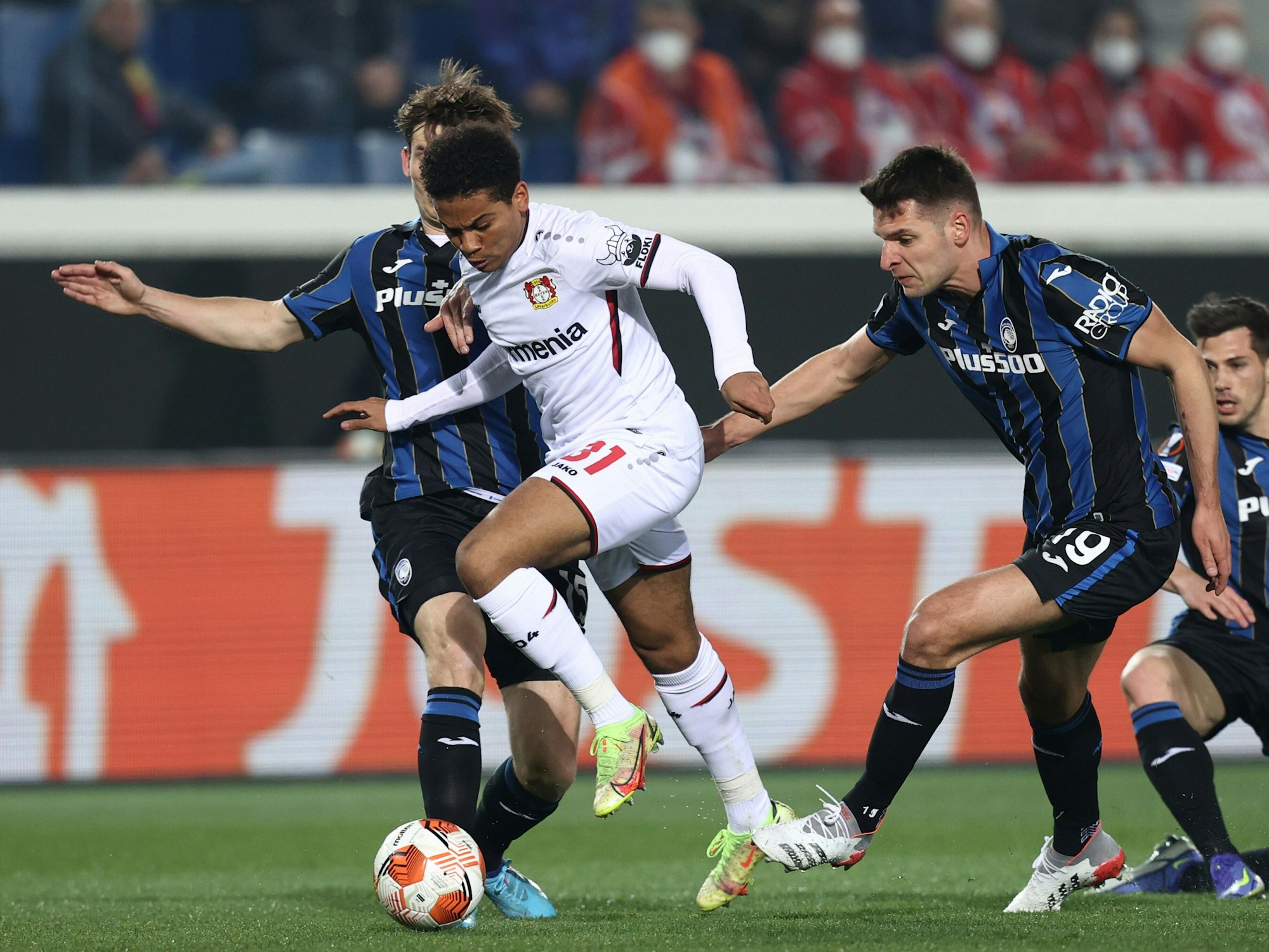 Marten De Roon (l) und Berat Djimsiti (2.v.r) von Atalanta Bergamo im Zweikampf mit Amine Adli (2.v.l) von Bayer Leverkusen.