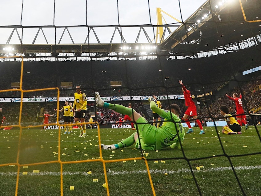Gregor Kobel (BVB) liegt auf dem Boden, der Ball zappelt im Netz.