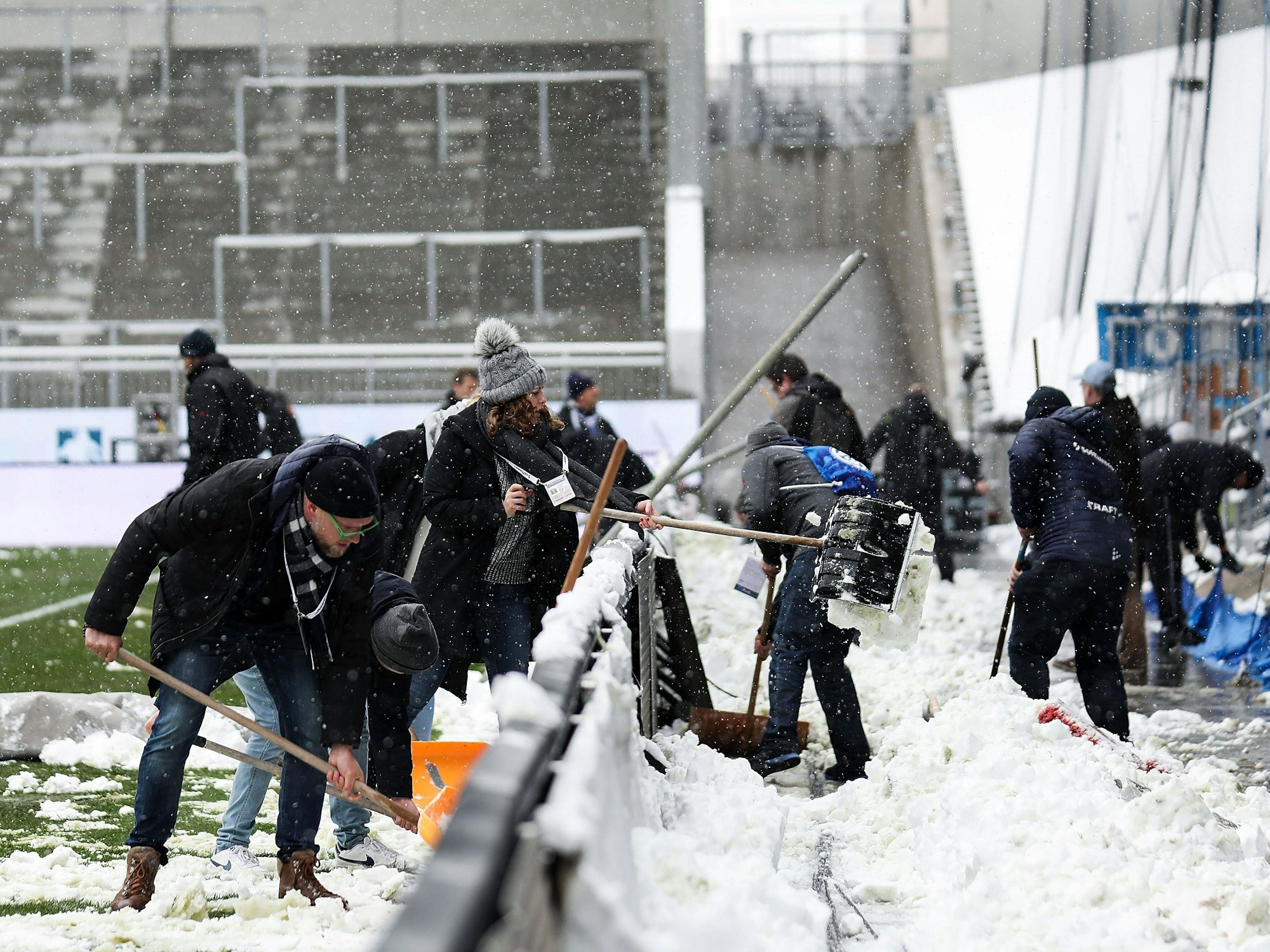 Fans und Mitarbeitende räumen Schnee vom Platz am Böllenfalltor
