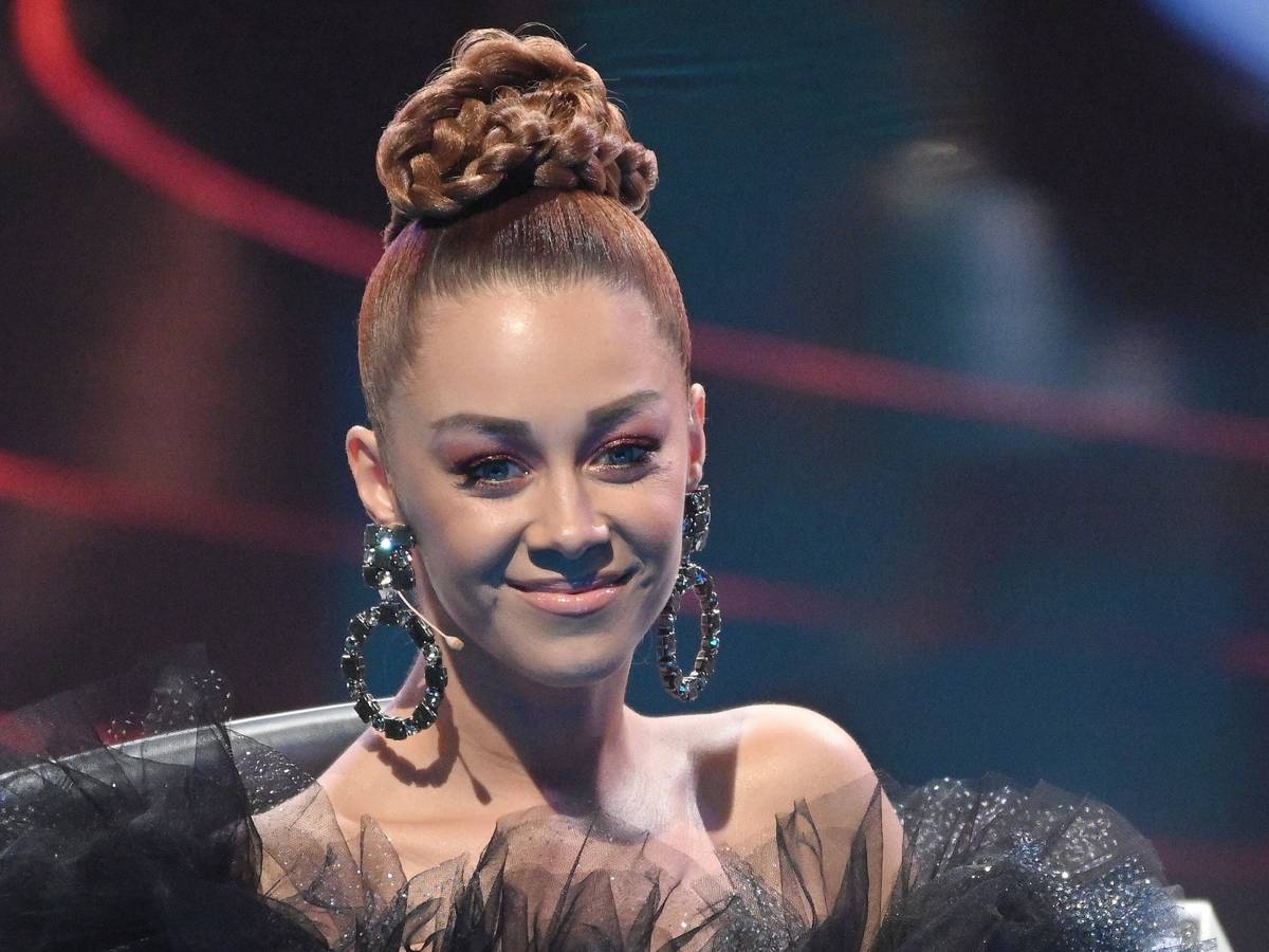Oana Nechiti trägt einen Dutt lächelt in Richtung Kamera.